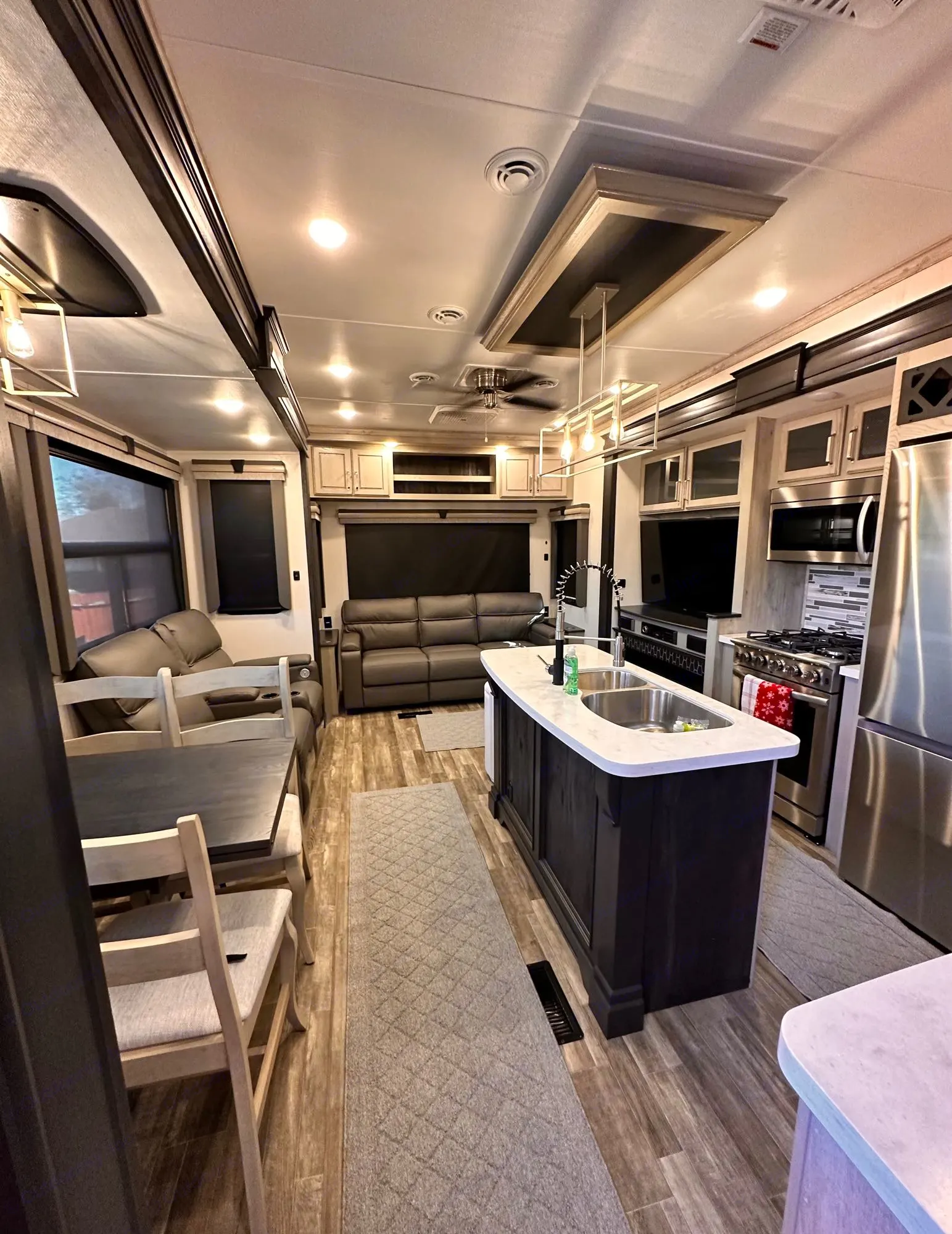 Spacious RV rental interior with a modern kitchen island, stainless steel. Keystone RV Alpine 2022