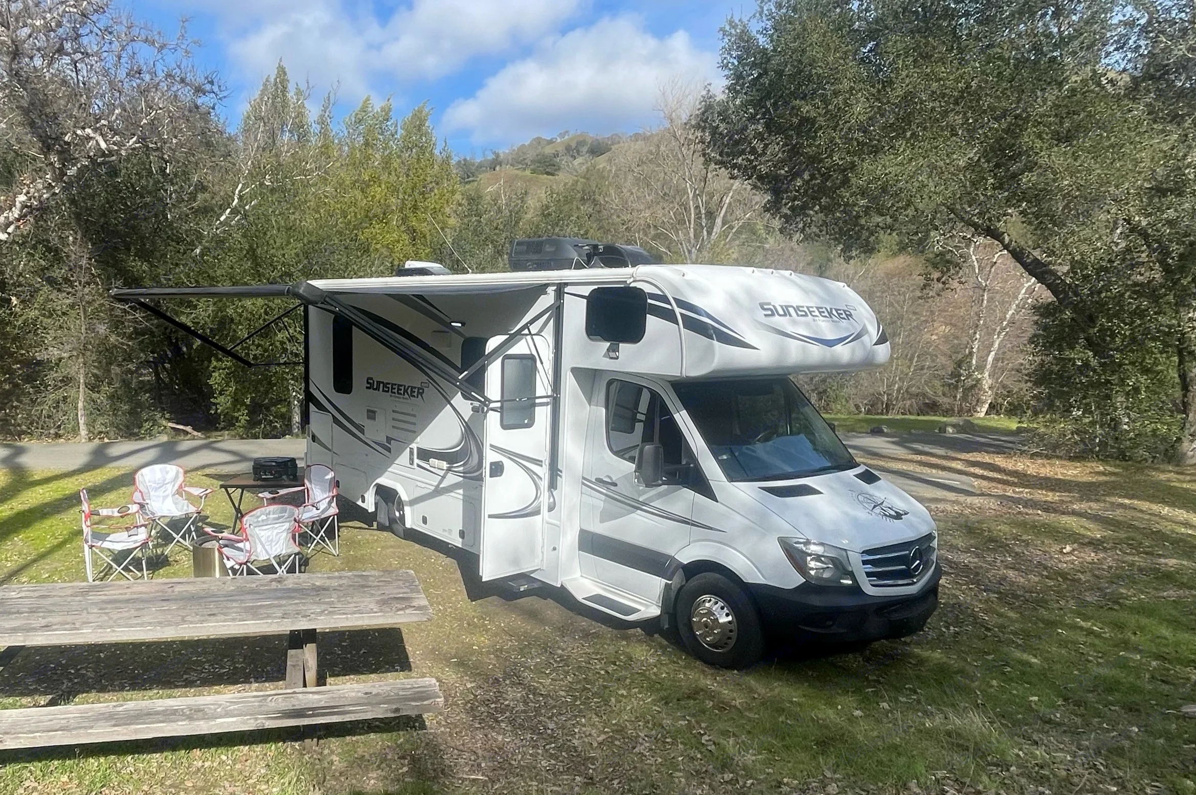 Camp is set up with propane gas grill, camp table, camp chairs, and optional Solo Stove fire pit.. Forest River Sunseeker MBS 2018