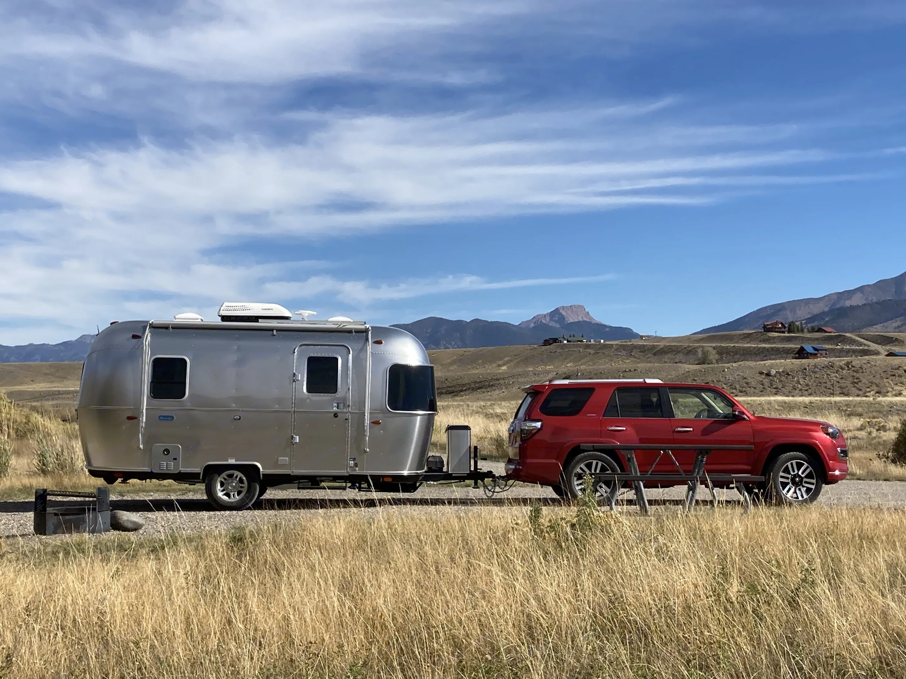 An Airstream travel trailer and red Toyota 4Runner at a scenic campsite. Perfect for your next RV rental adventure!. Airstream Bambi 2022