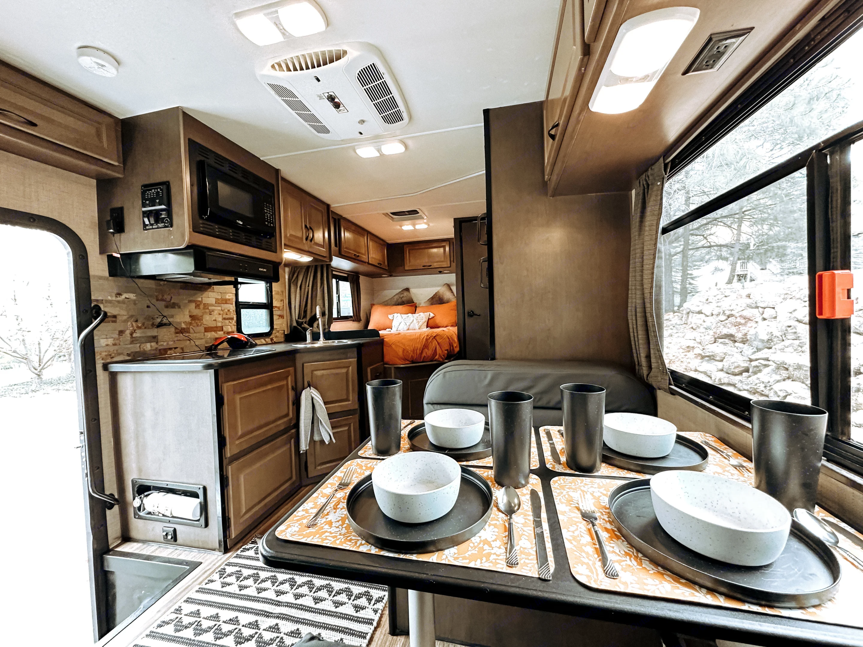Cozy RV rental interior with kitchen, dining area, and bed setup, perfect for travel and camping adventures.. Thor Majestic 2019