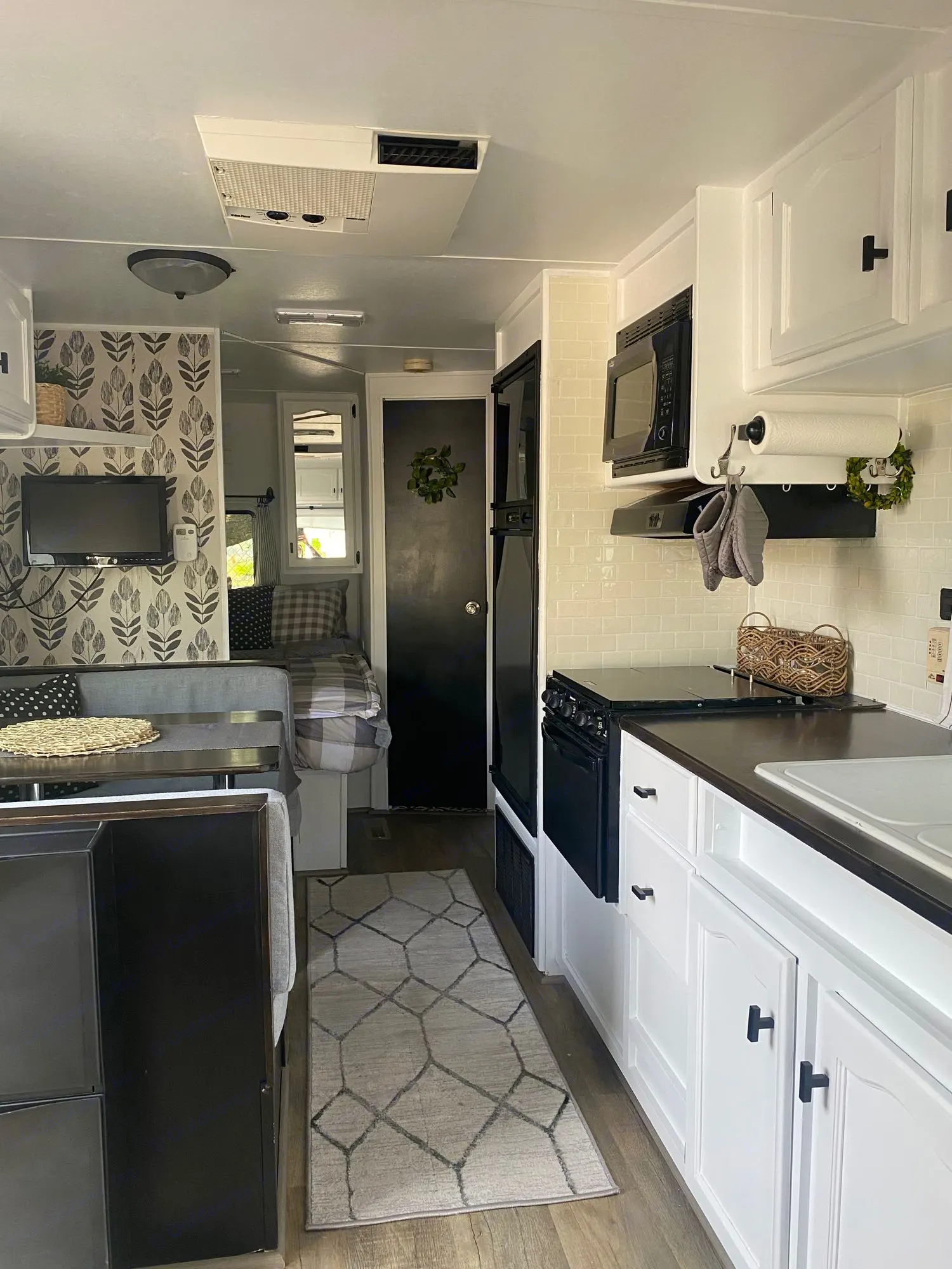 Inside a well-appointed RV rental, showing the updated kitchen, dinette, and cozy sleeping space.. Dutchmen Lite 2007
