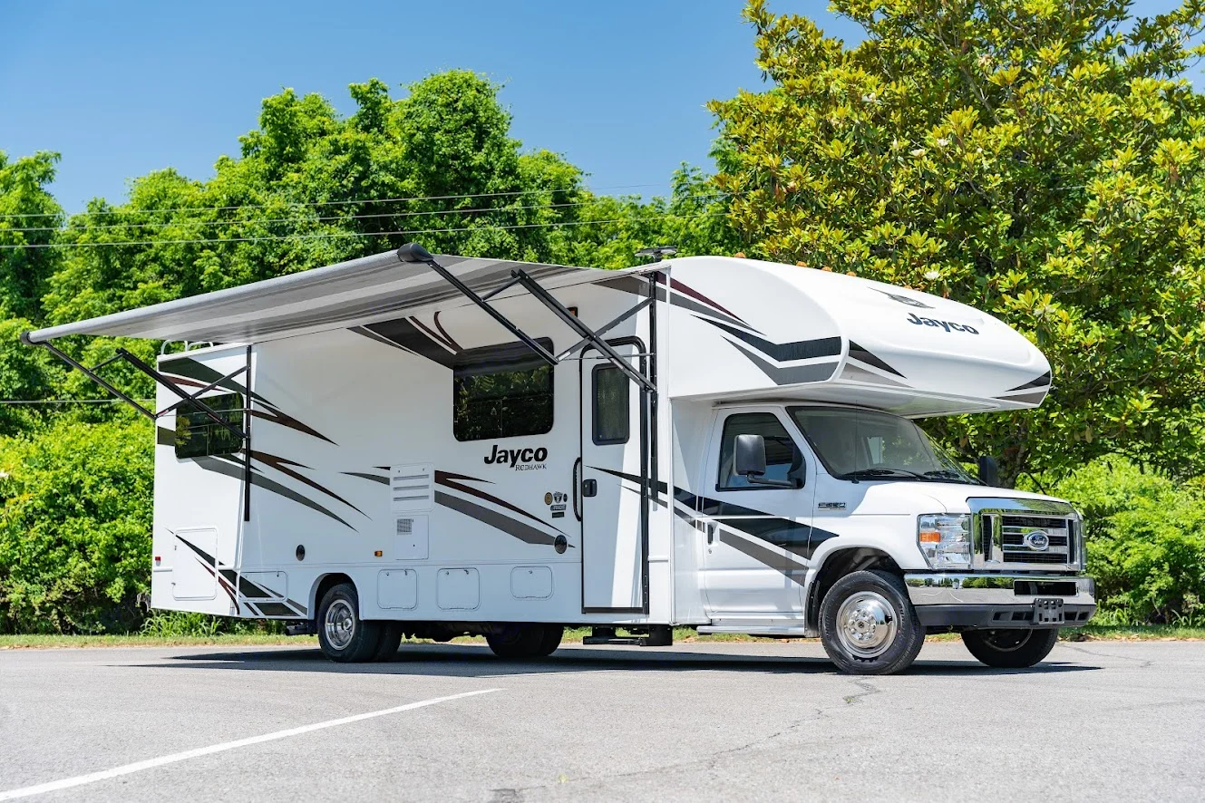 This white Jayco Redhawk Class C RV is parked with its awning extended. Ideal for your next rv rental road trip or outdoor adventure.. Jayco Redhawk 2019