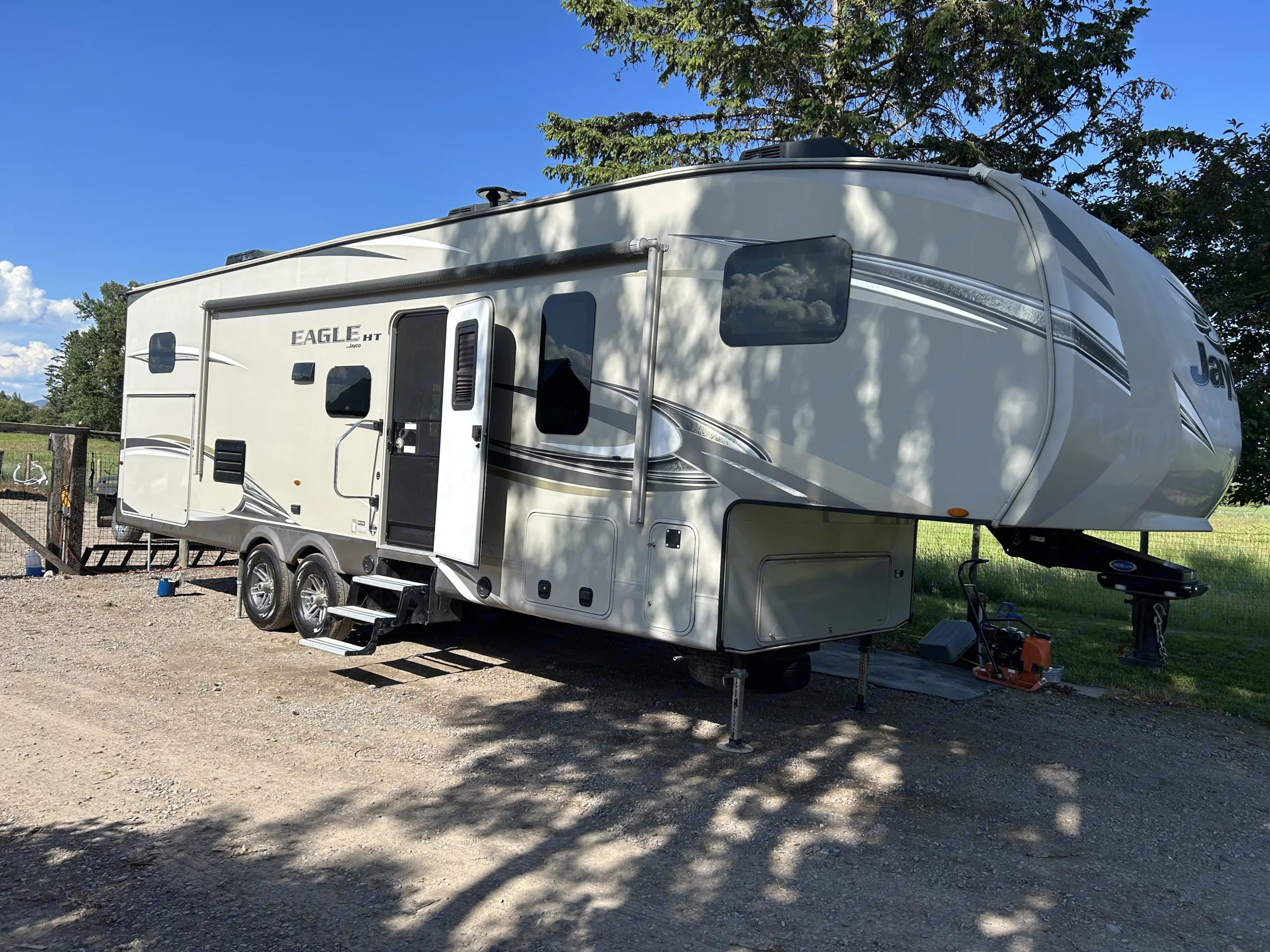 This Jayco Eagle HT fifth-wheel RV rental is parked on gravel at a sunny outdoor spot, ready for camping.. Jayco Eagle HT 2018