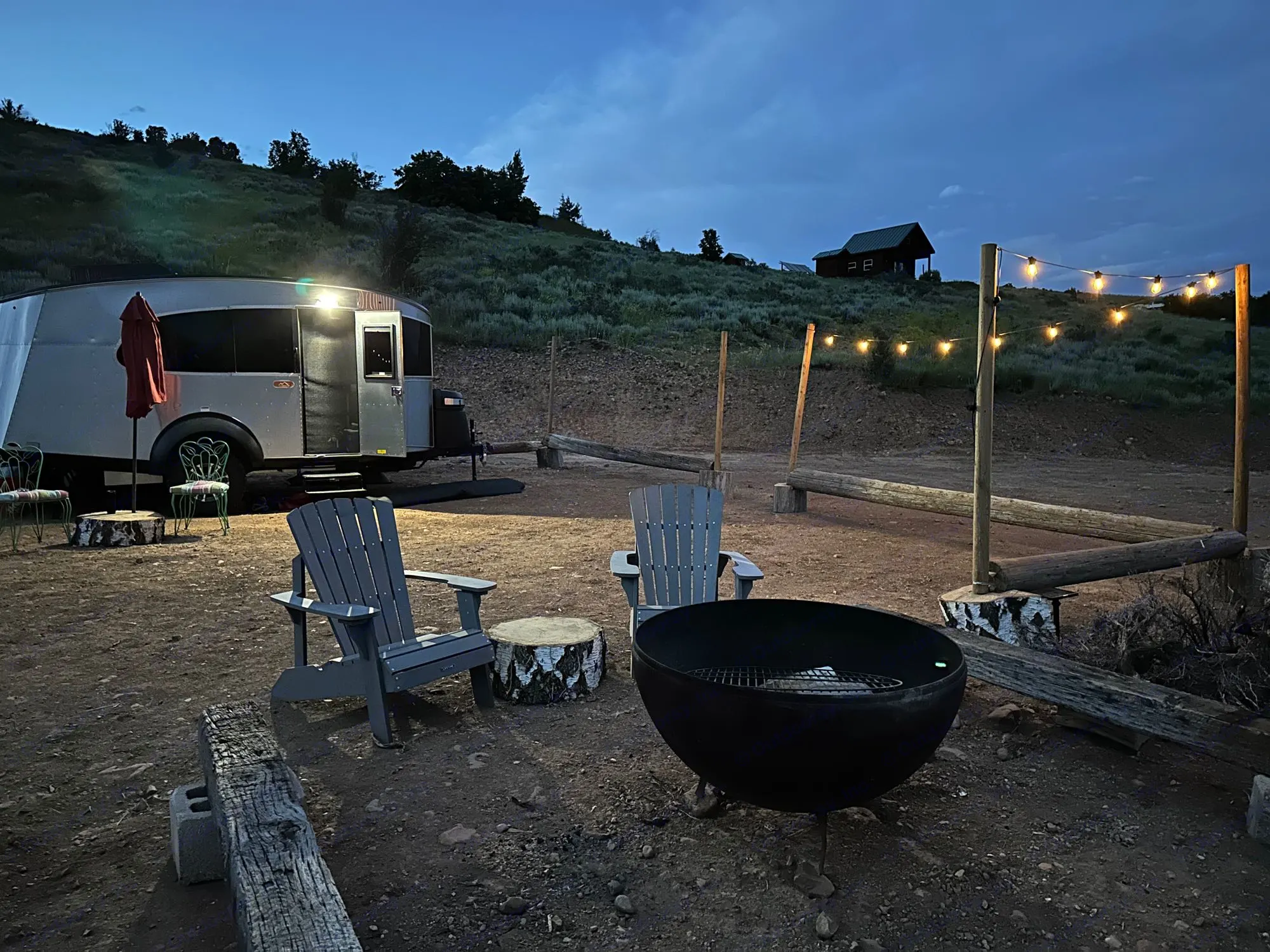 Cozy RV rental campsite at twilight, featuring. Airstream Basecamp 20X 2023