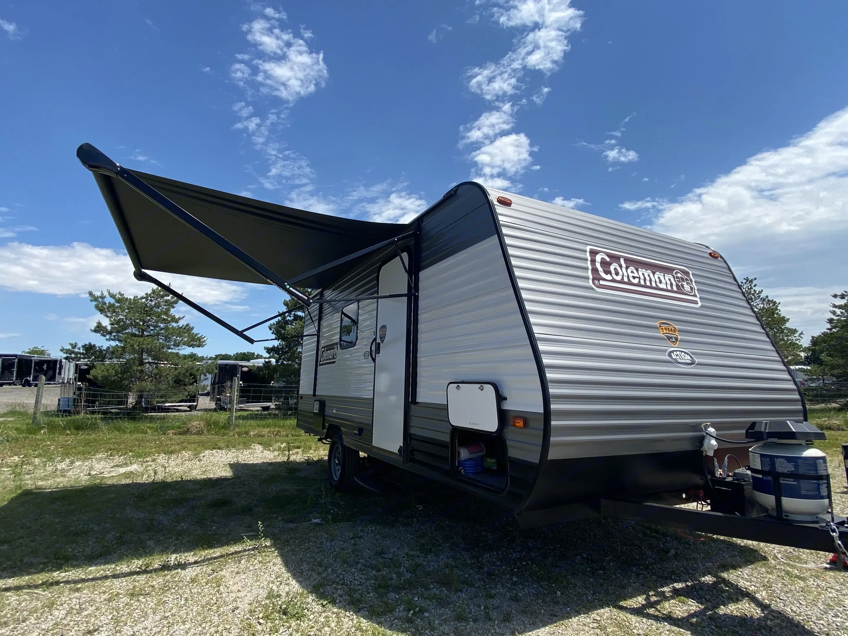 Photo of exterior camper showing awning and storage compartment. Dutchmen Coleman Lantern 2023
