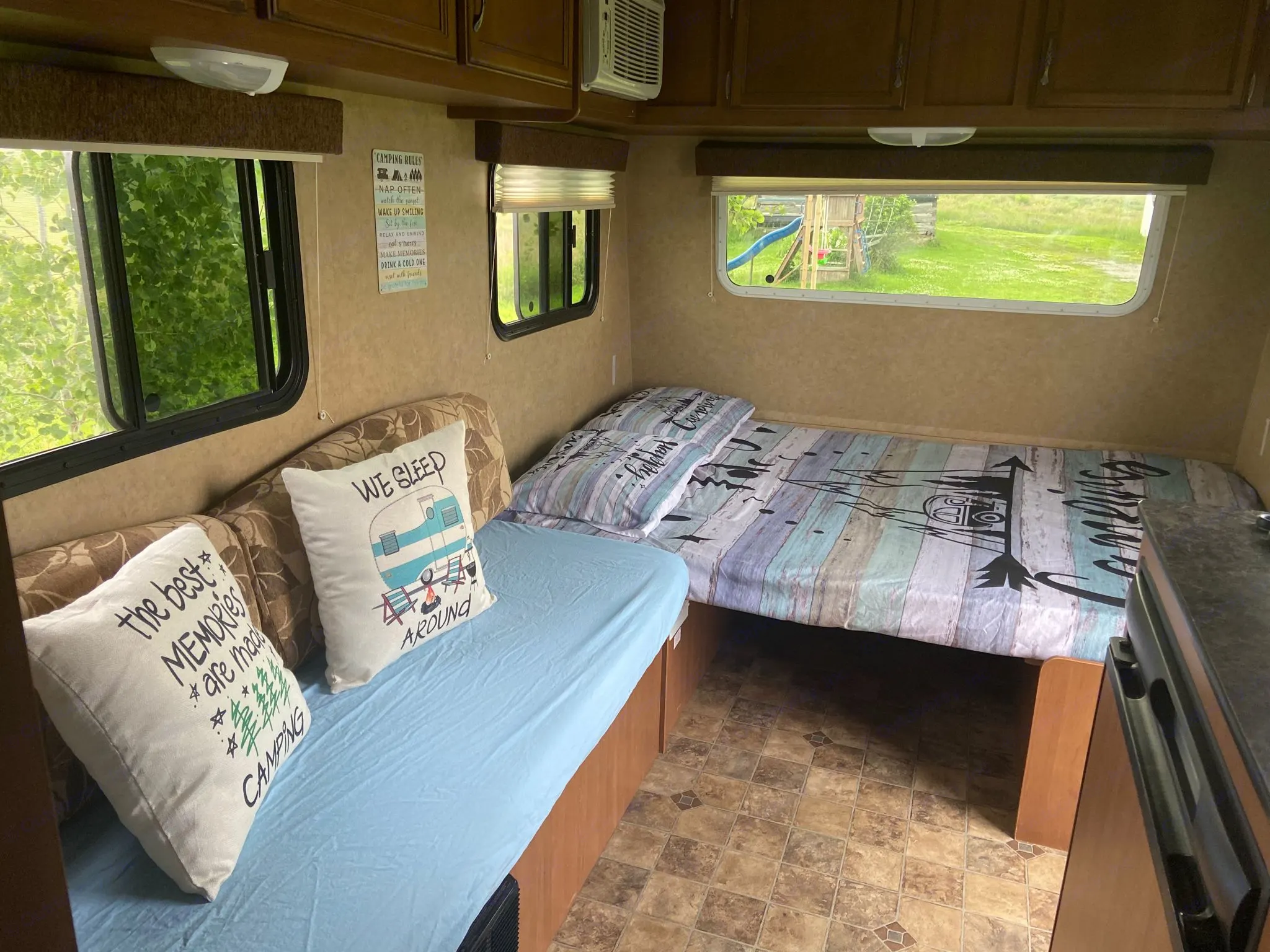 Cozy RV rental interior with two beds, large windows, and camping-themed decor for your next adventure.. Starcraft Launch 2013