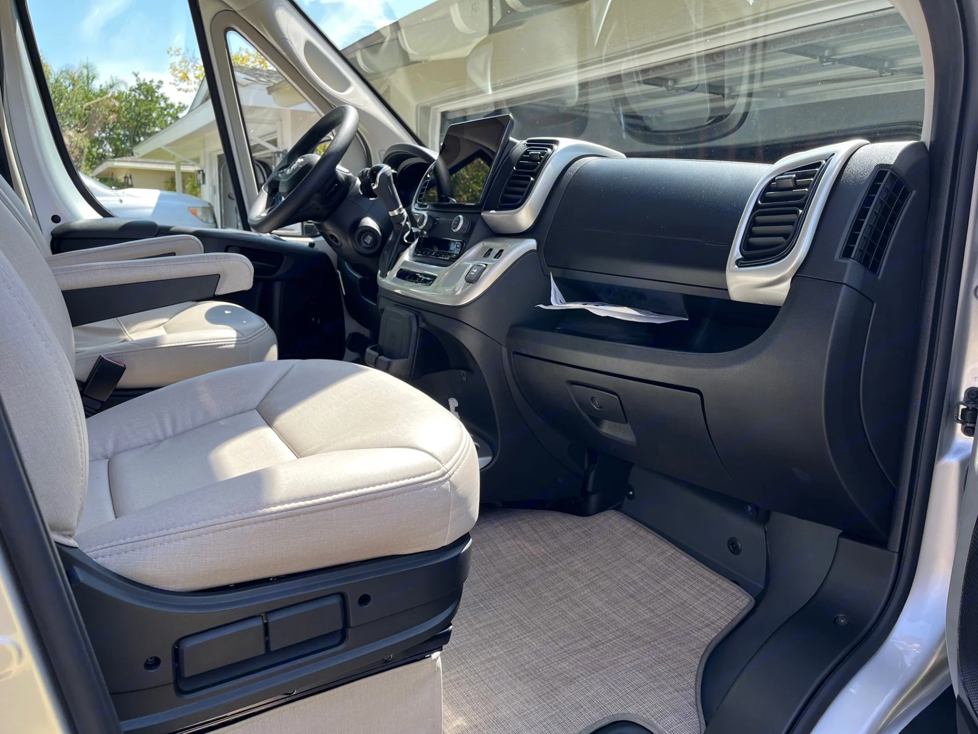 RV rental cab interior: driver's seat, modern dashboard with large display, and steering wheel visible.. Thor Sequnce 2023