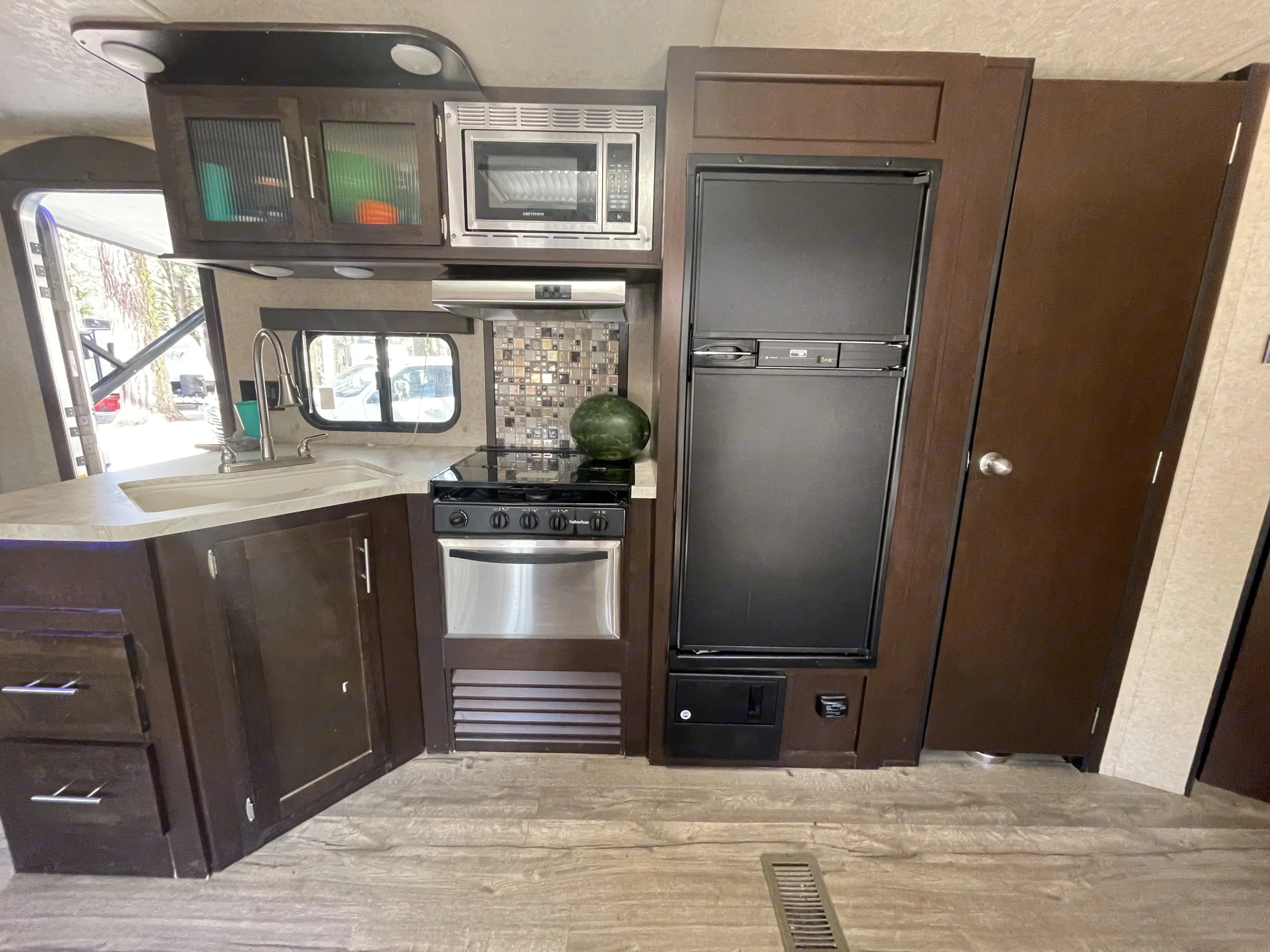 RV rental kitchen with microwave, stove, refrigerator, and sink. Perfect for on-the-go cooking & living.. Forest River Cherokee 2018