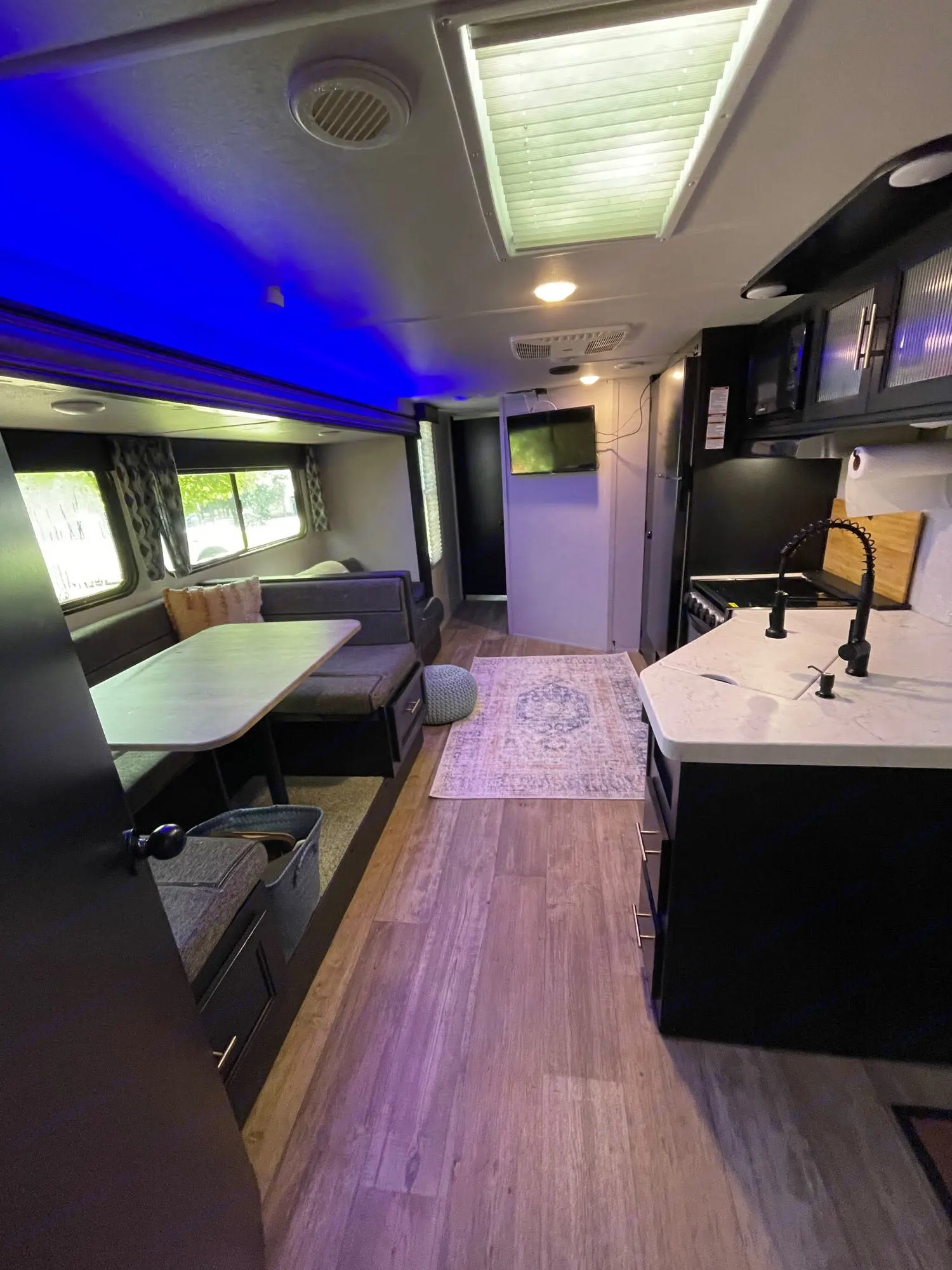 Spacious RV rental interior featuring a full kitchen, dinette, and cozy living space with blue accent lighting.. Forest River Cherokee Grey Wolf 2021
