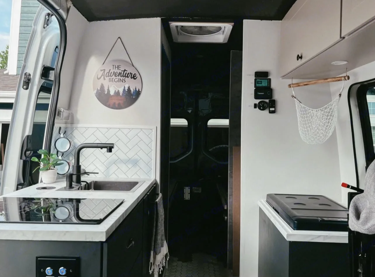 Kitchen area with sink, dual induction cooktop (SUPER FAST), and fridge.. Mercedes-Benz Sprinter 2019