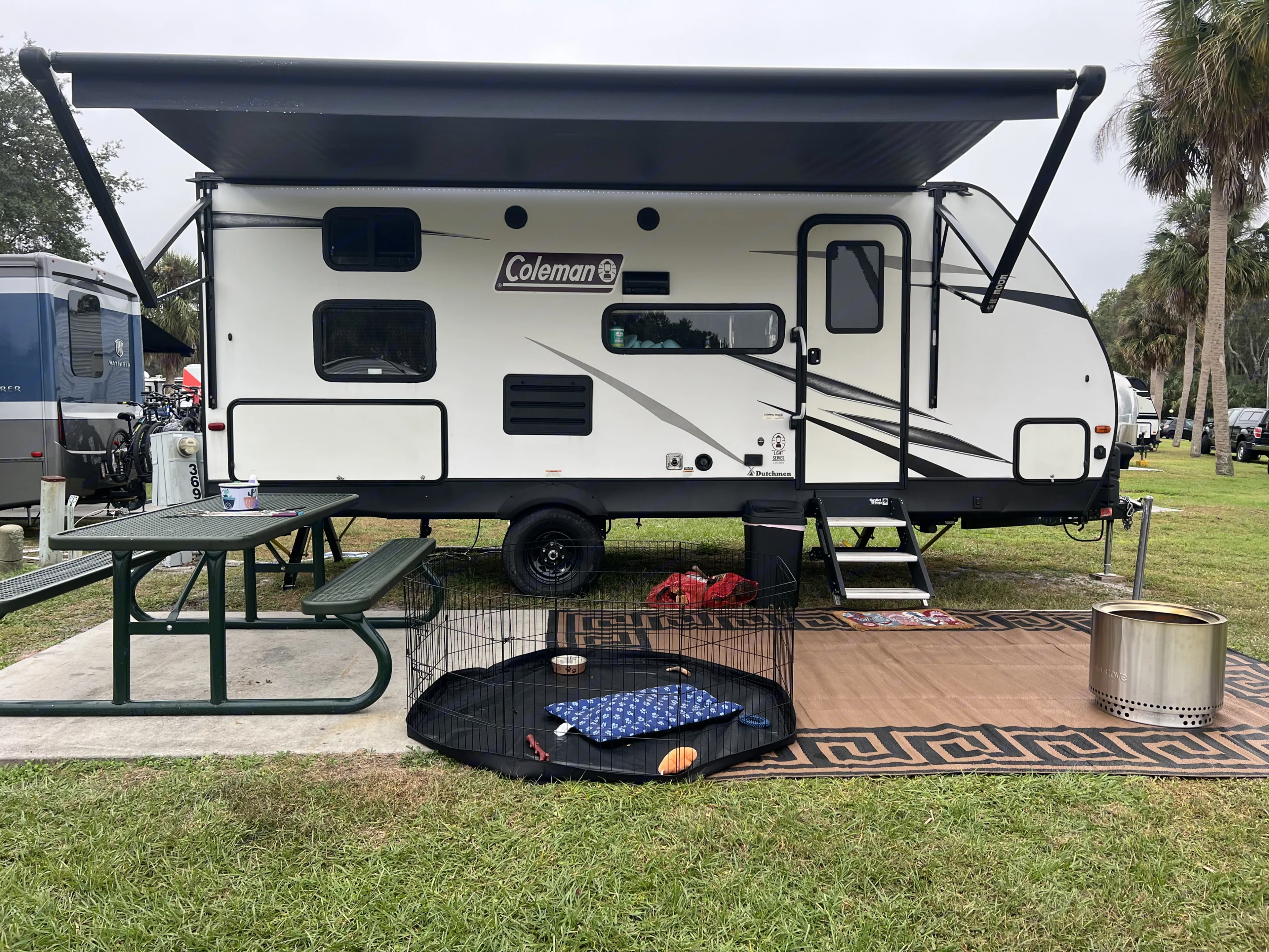 Entrance side with outdoor kitchen and slide through storage. Dutchmen Coleman Light LX 2021