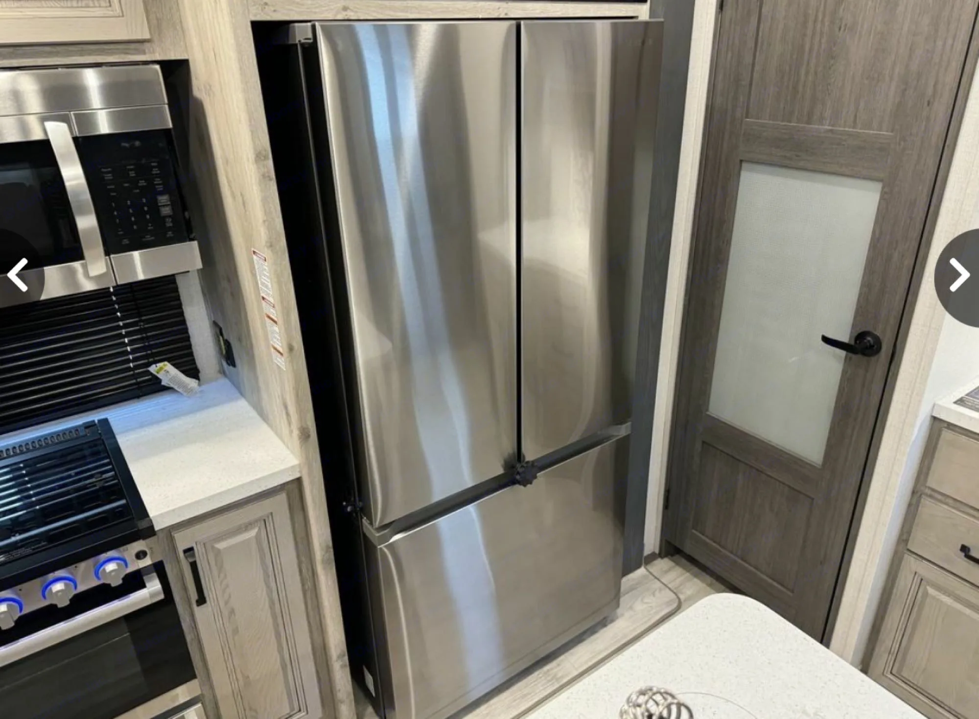 This RV rental features a modern kitchen with a stainless steel French door refrigerator, microwave, and gas range.. Keystone Alpine Avalanche 2024