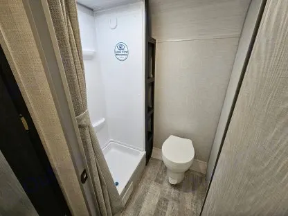 Inside an RV rental: a clean, compact bathroom featuring a shower, toilet, and built-in shelving.. R-Pod R-Pod Trailer 2022