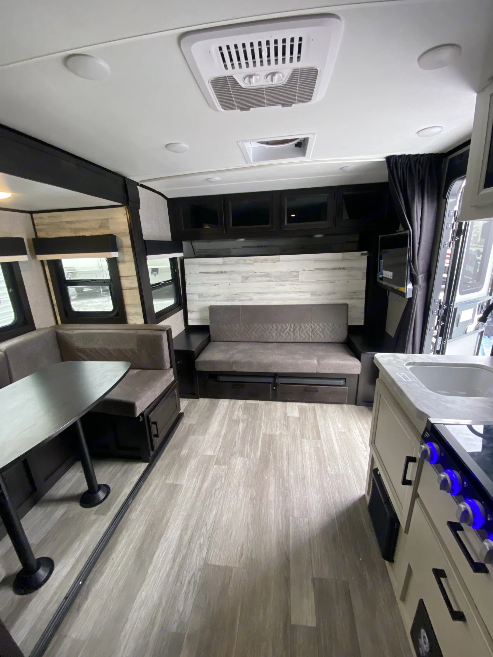Inside an RV rental: a modern living space featuring a dinette, convertible sofa, compact kitchen, & ample storage.. Jayco Jay Feather Micro 2023
