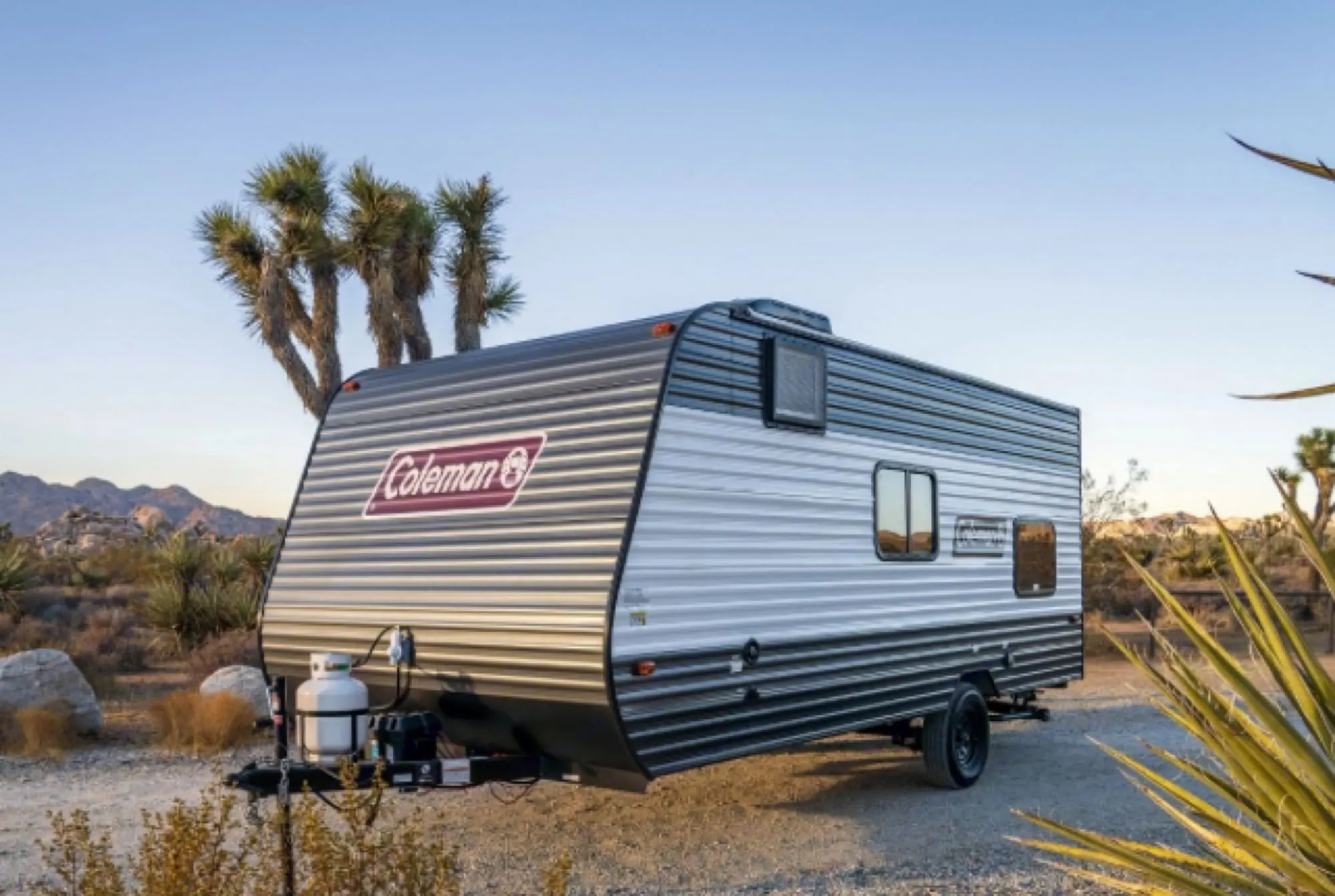 Experience nature with an RV rental: A modern Coleman travel trailer parked among Joshua trees in a scenic desert landscape.. Coleman Lantern 17b 2024
