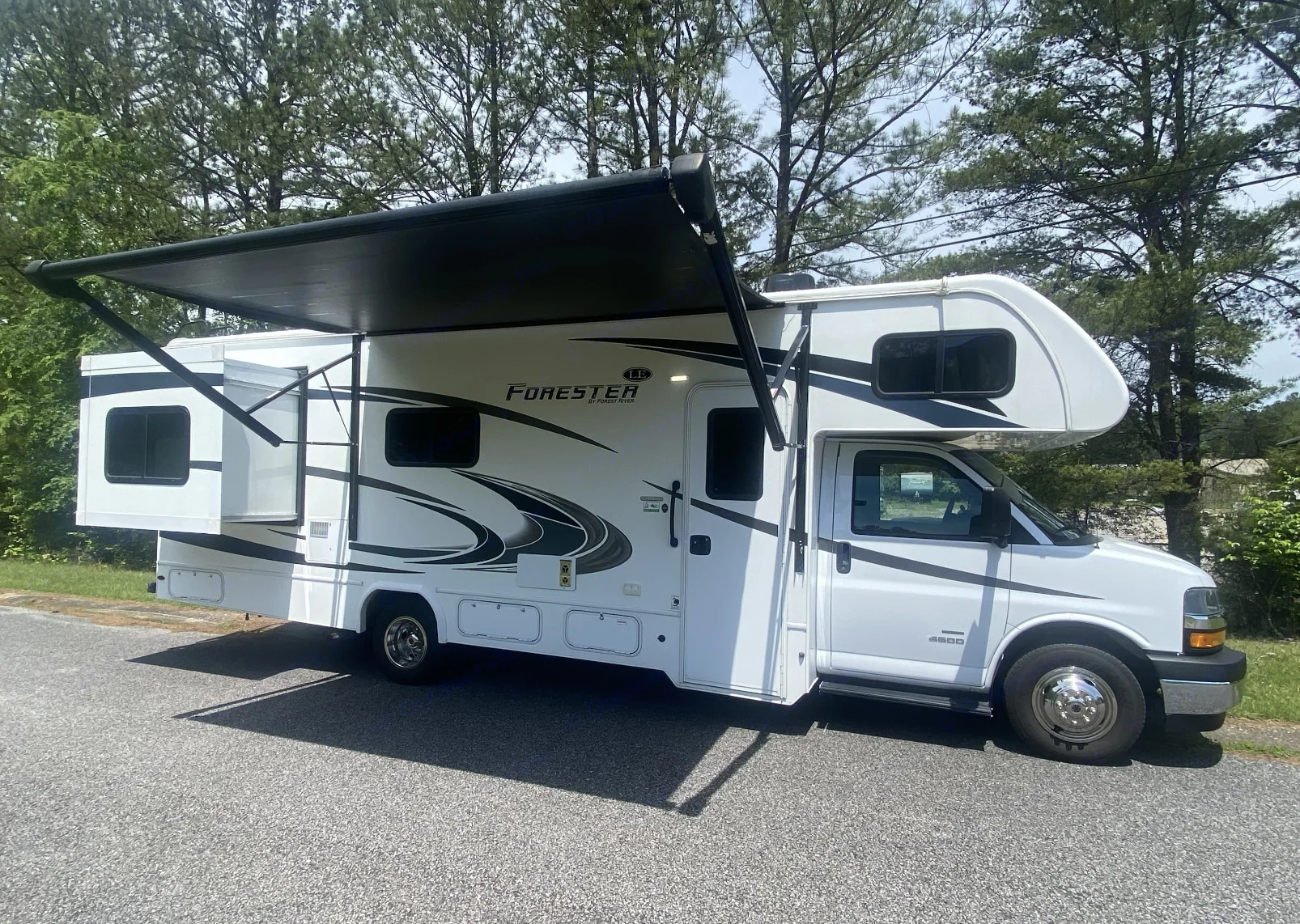 White Forester Class C motorhome rv rental with awning and slide-out extended, perfect for road trips.. Forest River Forester 2020