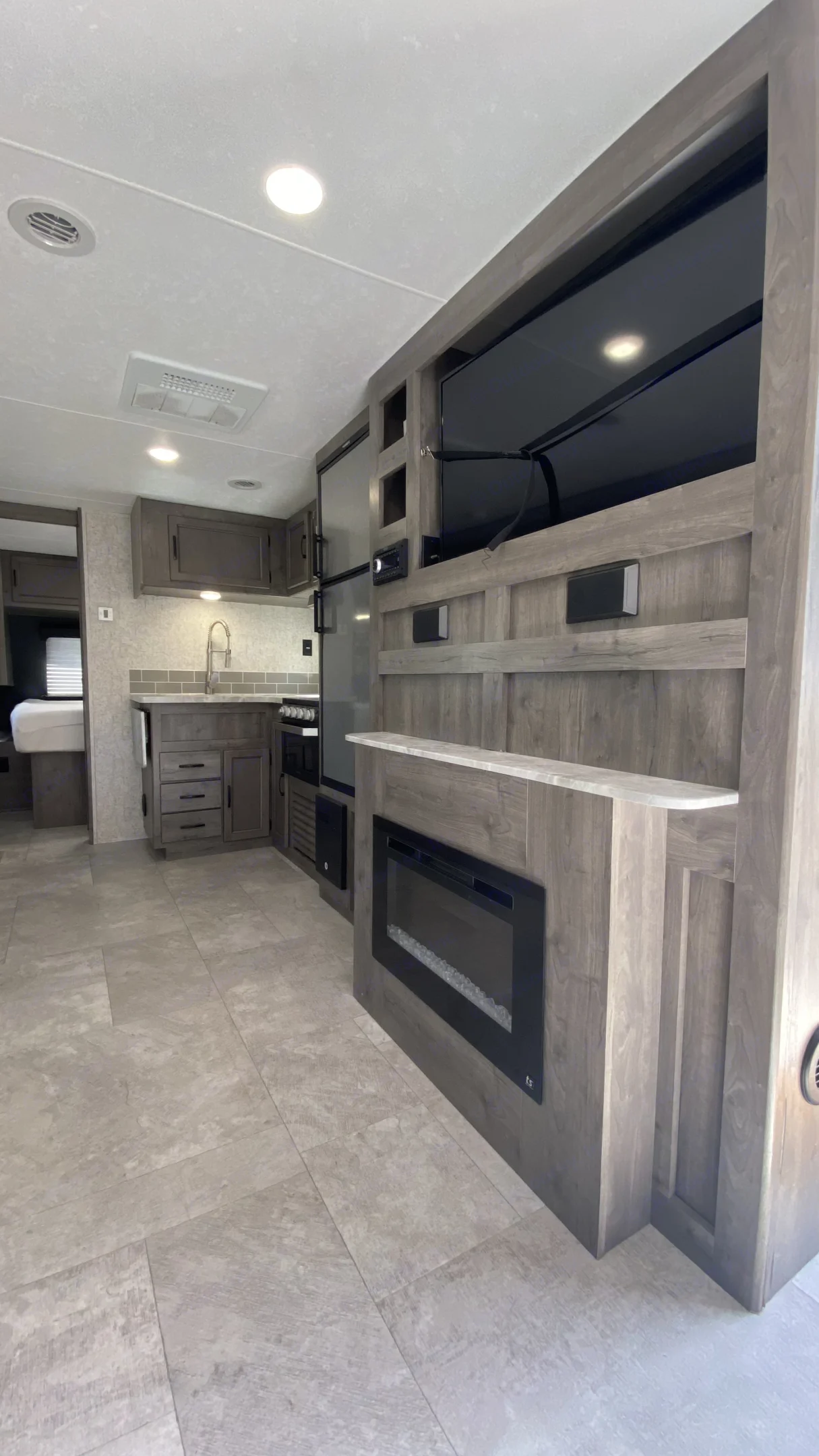 Additional warmth and ambience from the fireplace with a tv above and more storage behind.. Coachmen Apex 2020