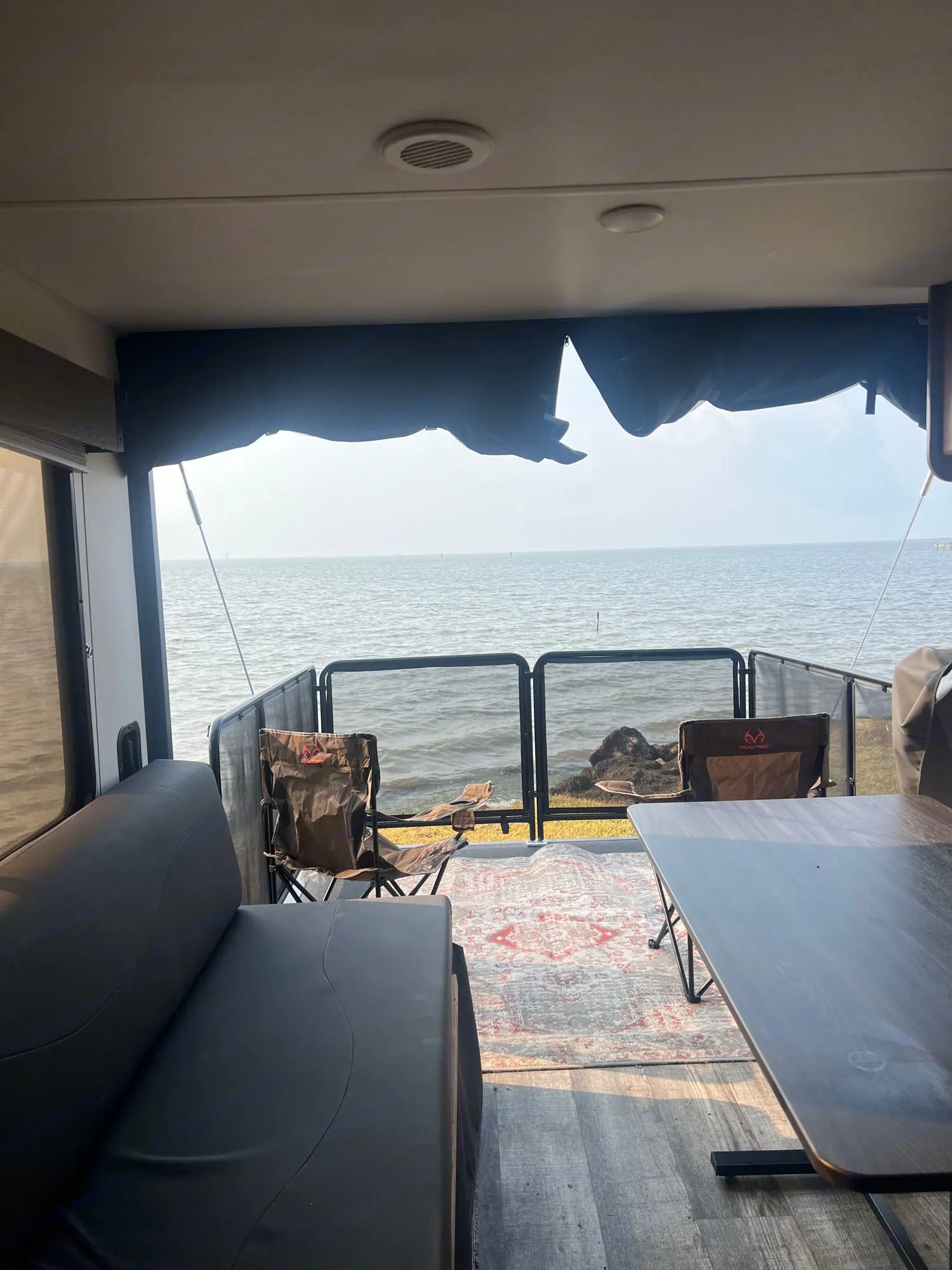 Toy hauler ramp converts into an outdoor patio, looking out from the dining area . Forest River Cherokee Wolf Pack Toy Hauler 2024