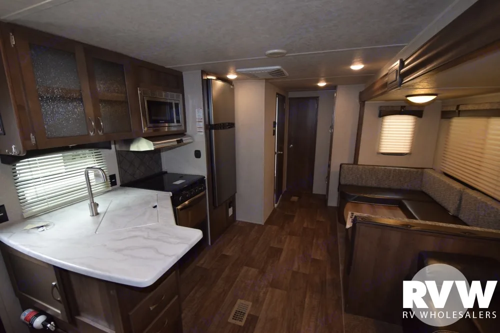 Spacious RV rental interior with a modern kitchen, microwave, stove, fridge, and a cozy U-shaped dinette.. Forest River Palomino Puma 2018