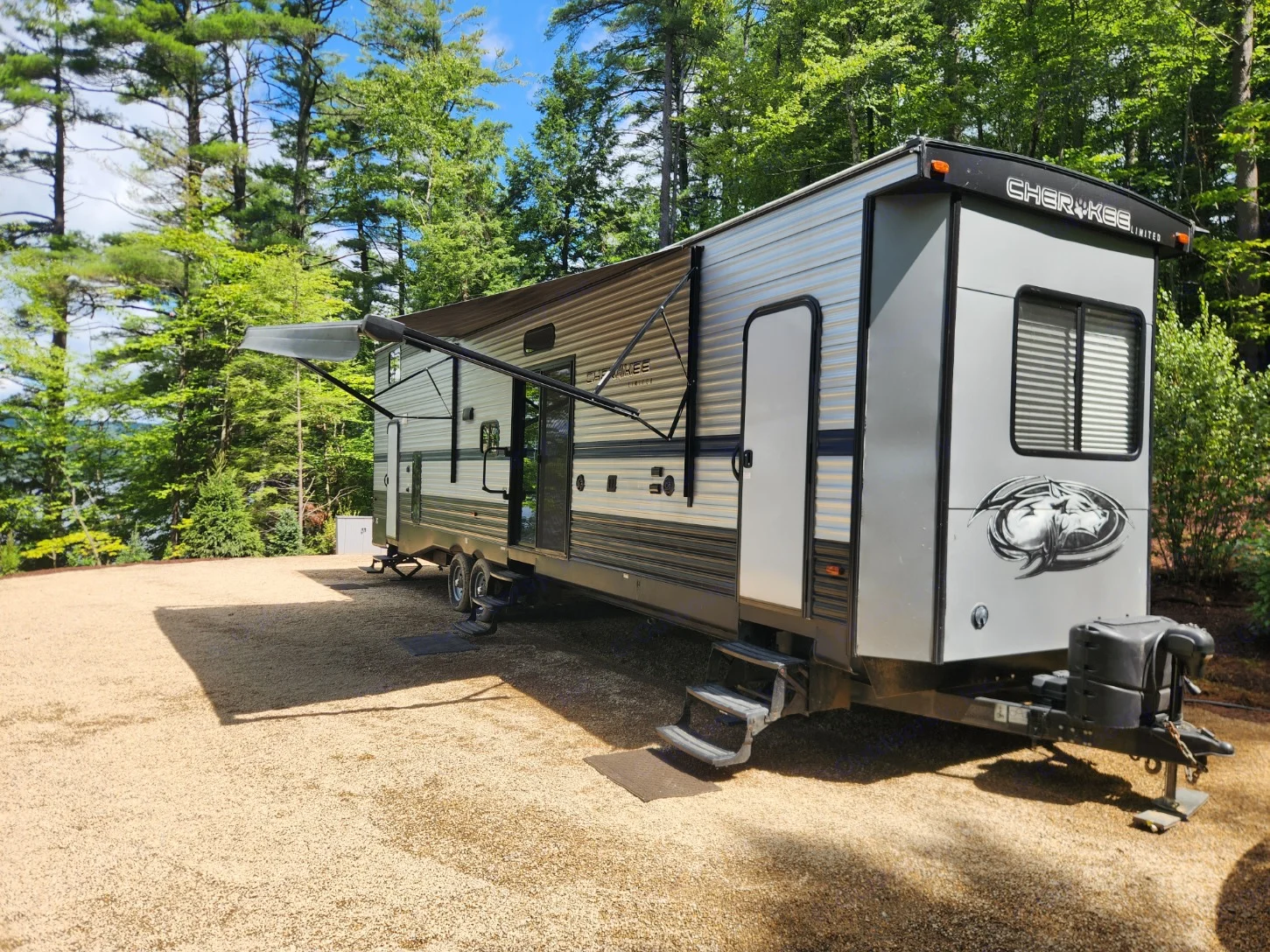 Spacious RV rental parked at a serene lakeside campsite, ready for your nature escape!. forest river cherokee 39ca 2019