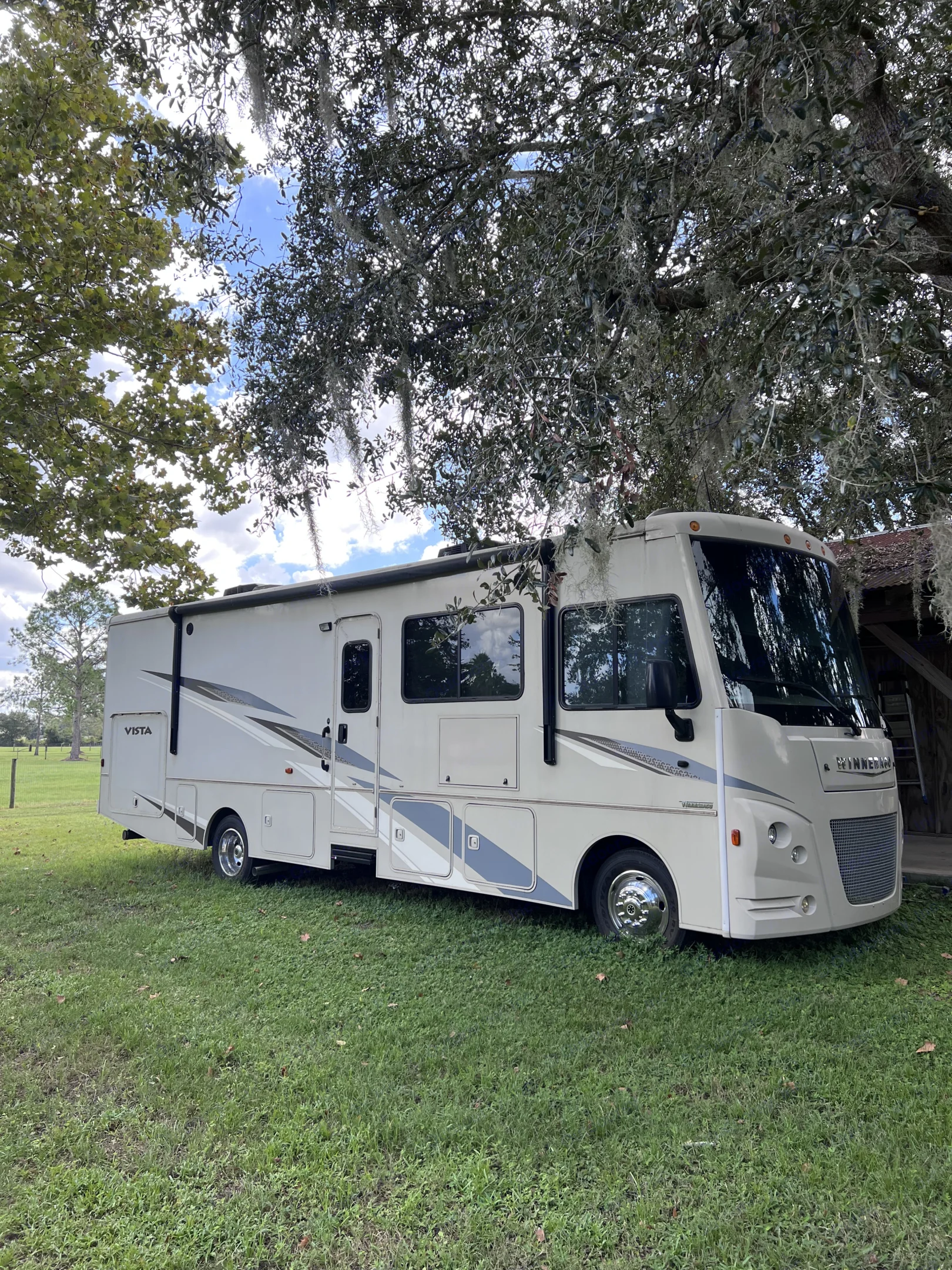 Winnebago Vista RV rental parked on green grass under mossy trees. Perfect for your next travel adventure!. Winnebago Vista 2021