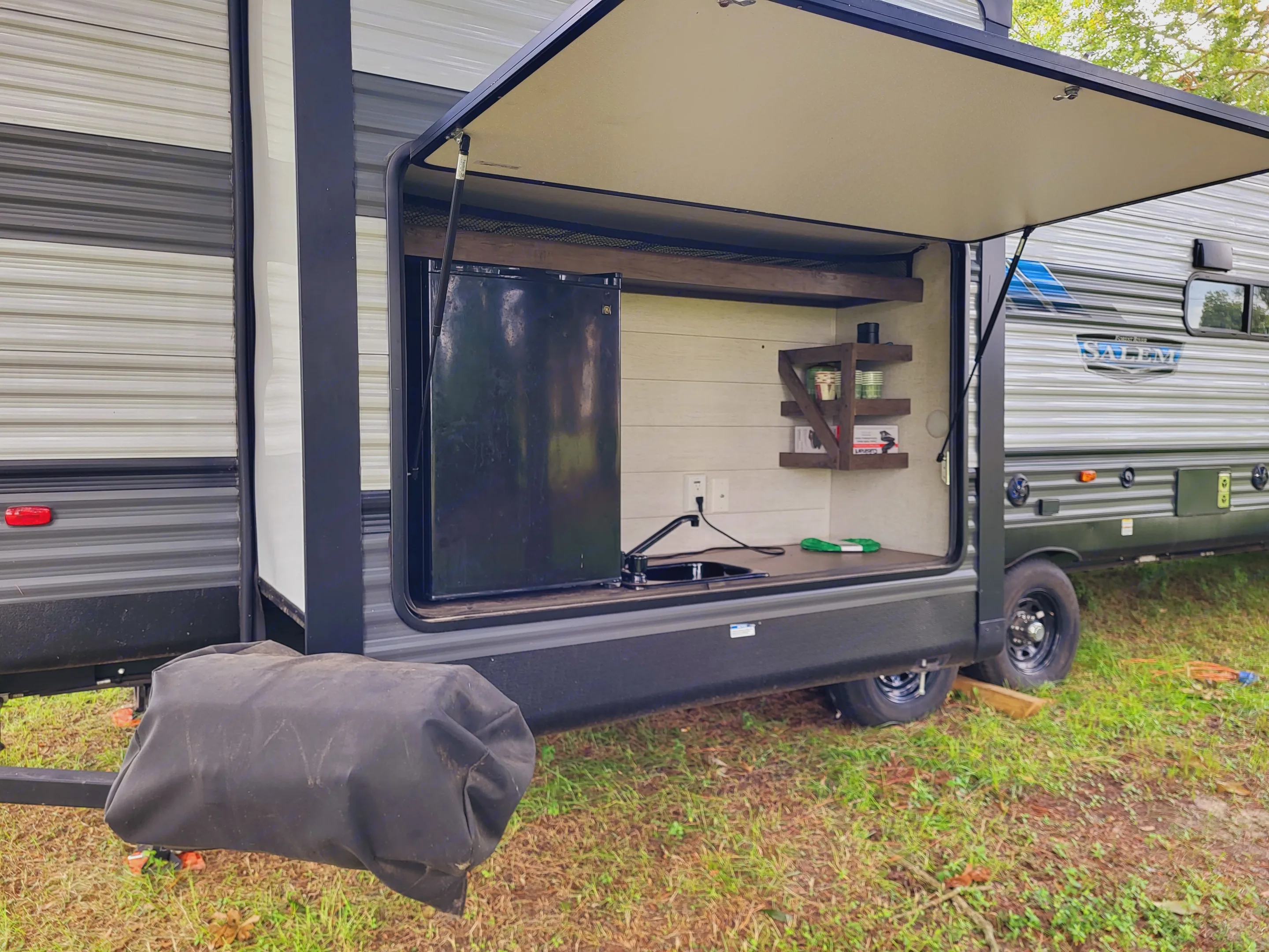 Outdoor Kitchen With Mini Fridge, Sink, Counter Space. Mini Waffle Iron, Gas Grill Attached To Bumper With Swingout Arm. Griddle Grate Attachment. Icee Maker. Forest River Salem 2021