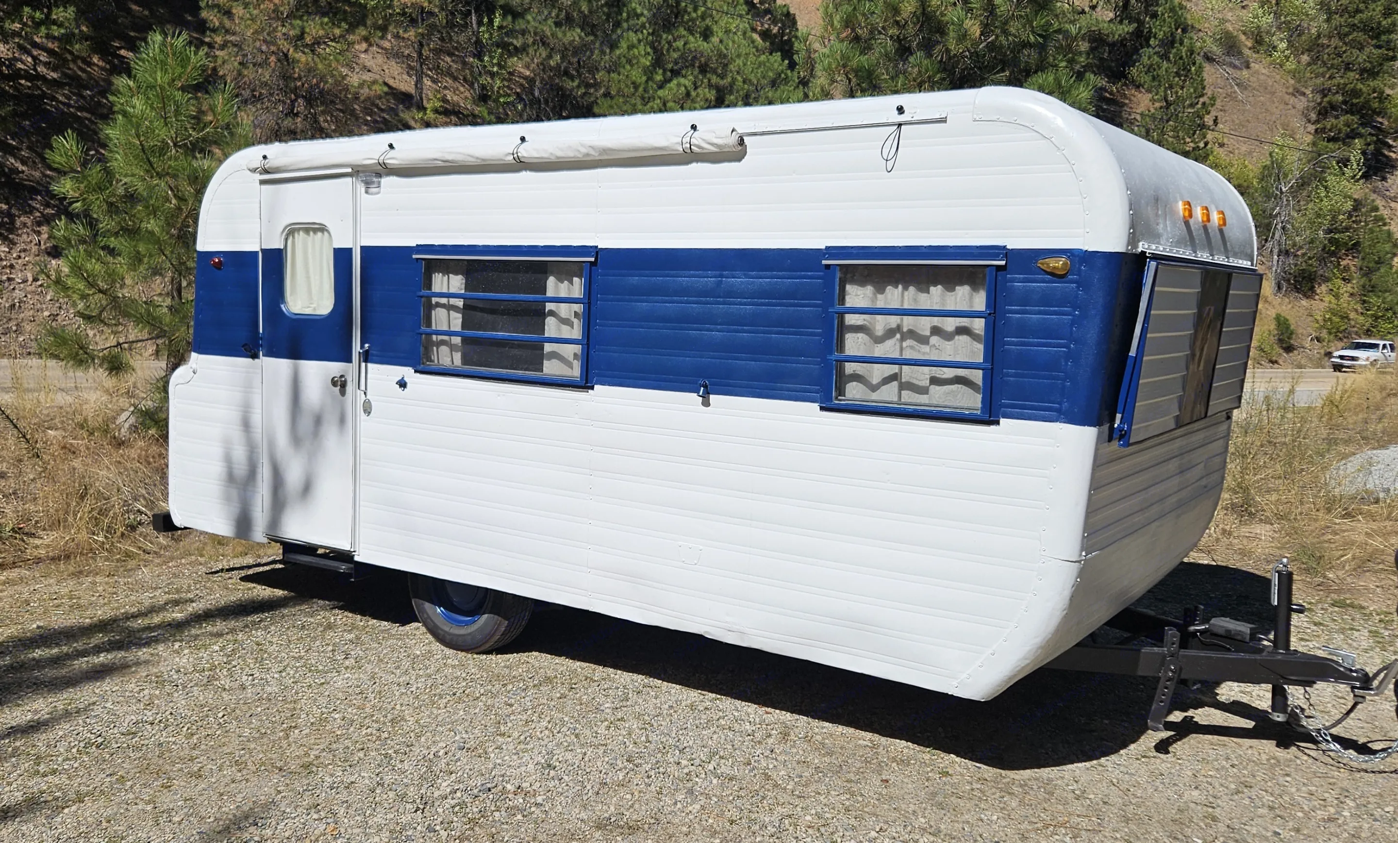 A beautifully restored vintage white and blue travel trailer, ideal for your next RV rental. Yellowstone B21539 - 19' 1967