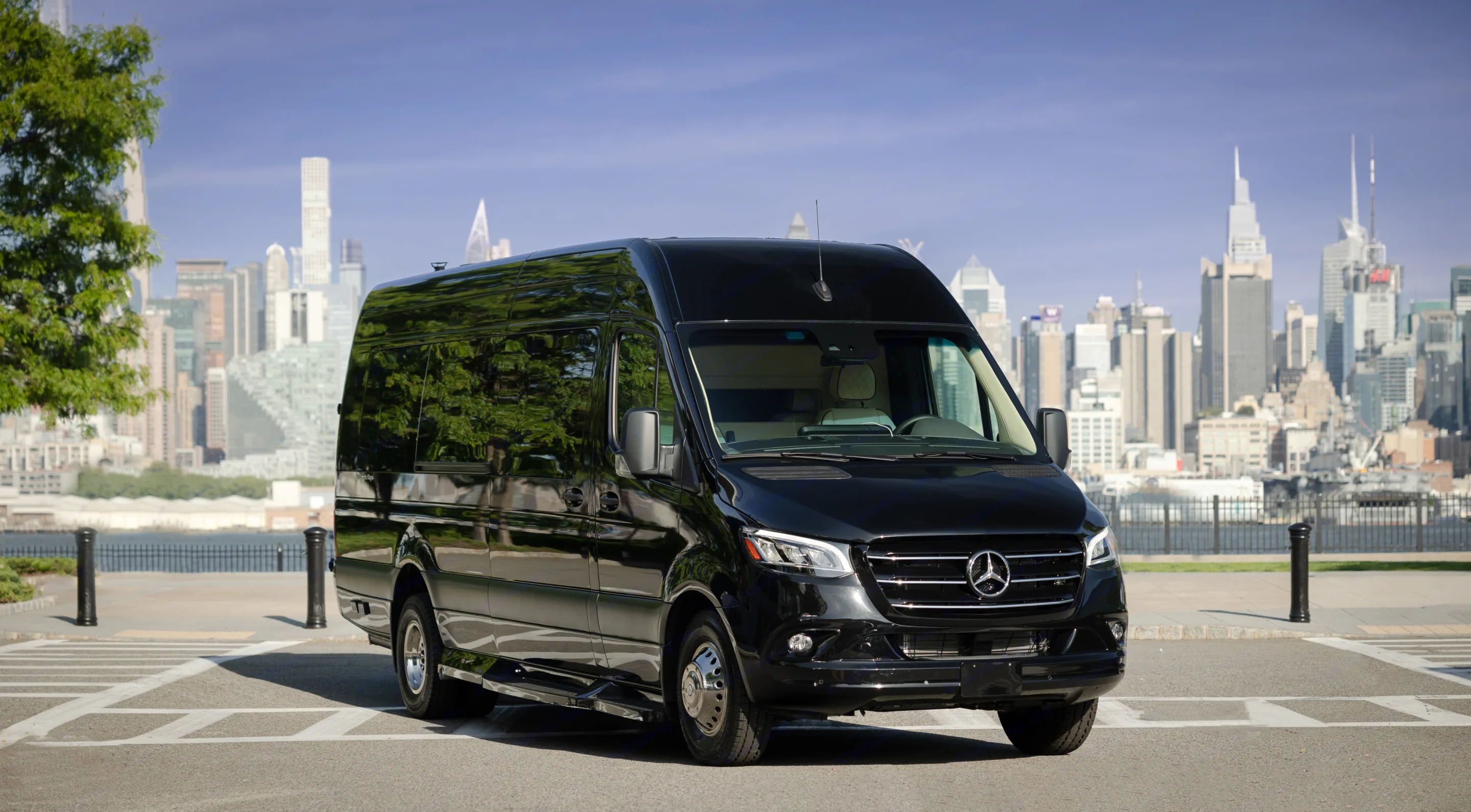 Black Mercedes-Benz Sprinter van for luxury travel or RV rental, parked before a stunning city skyline.. Midwest Automotive Designs Ultimate Cruiser 2024