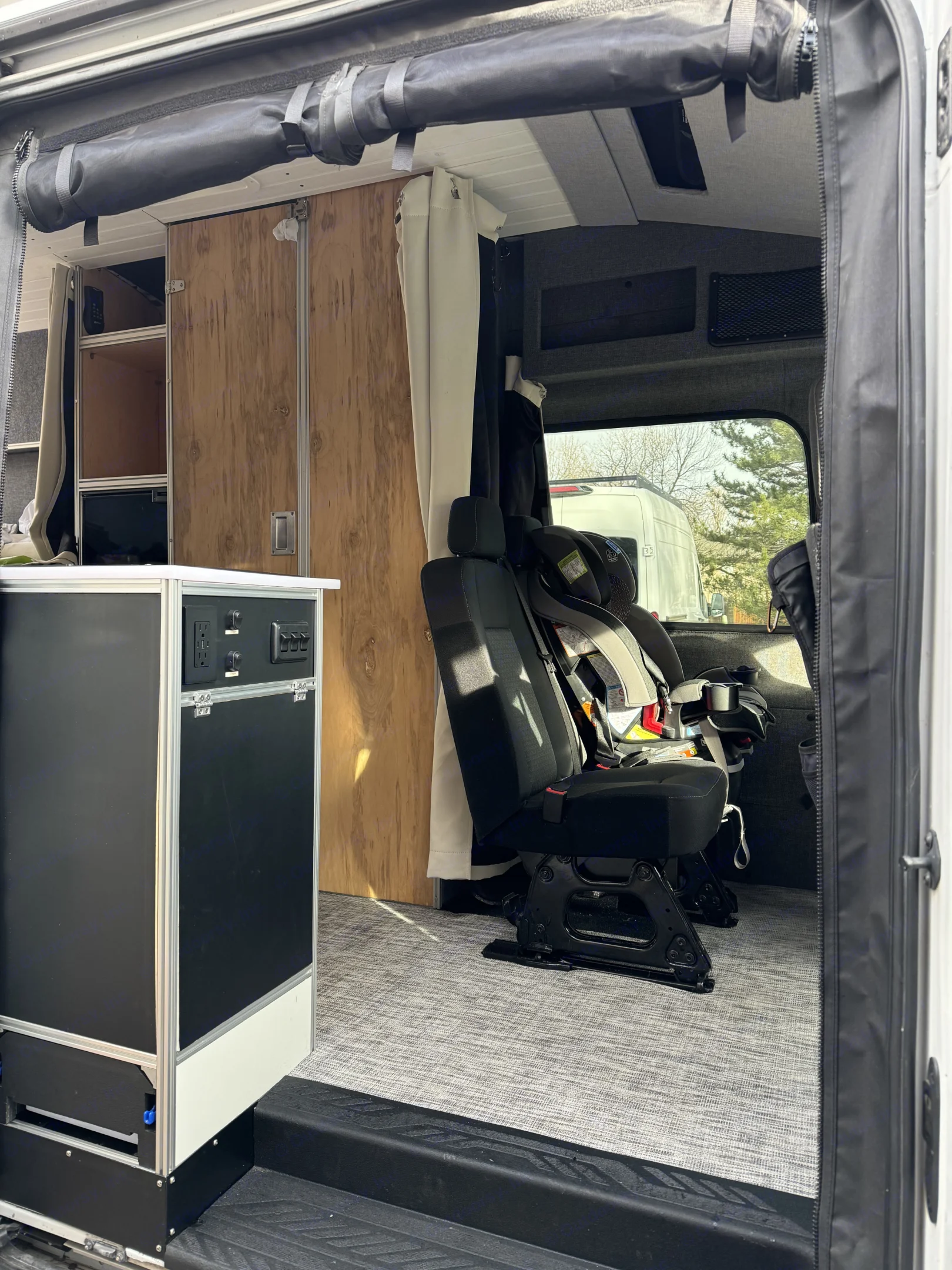 Interior features magnetic bug screen at the entrance. This photo shows the second rows of seats which can be accomodated with child seat if needed. Ford Transit 2015