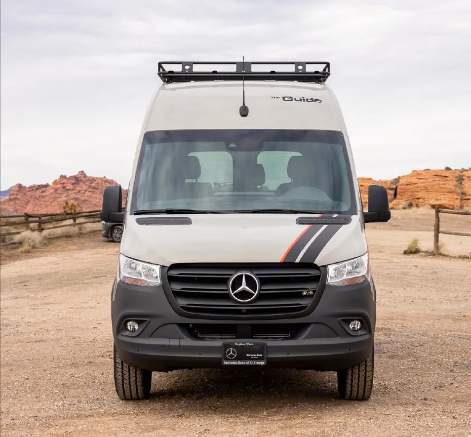 Front view of a Mercedes-Benz Sprinter RV rental van, "The Guide", with a roof rack, in a desert landscape.. Mercedez Benz Sprinter 2021