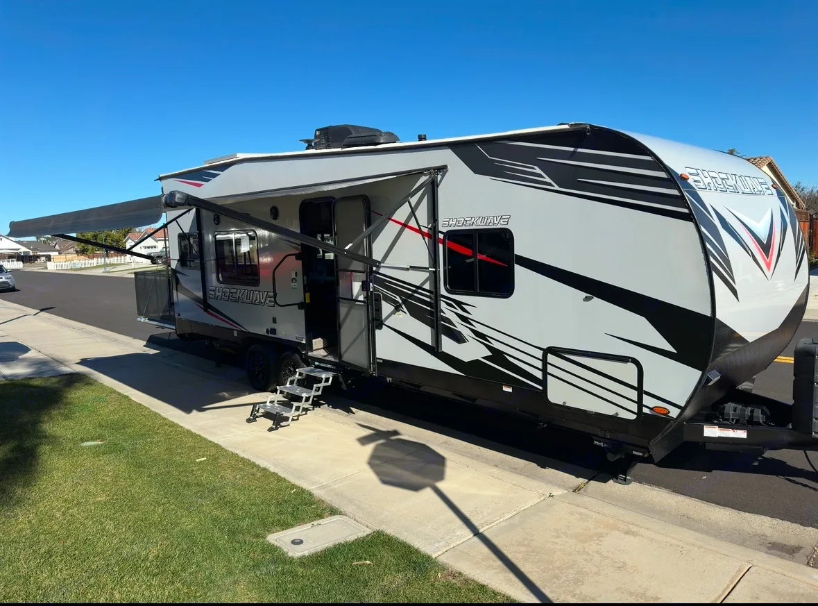 Modern Shockwave toy hauler RV rental with extended awning and convenient steps, ready for your next adventure.. Forest River Shockwave 2021