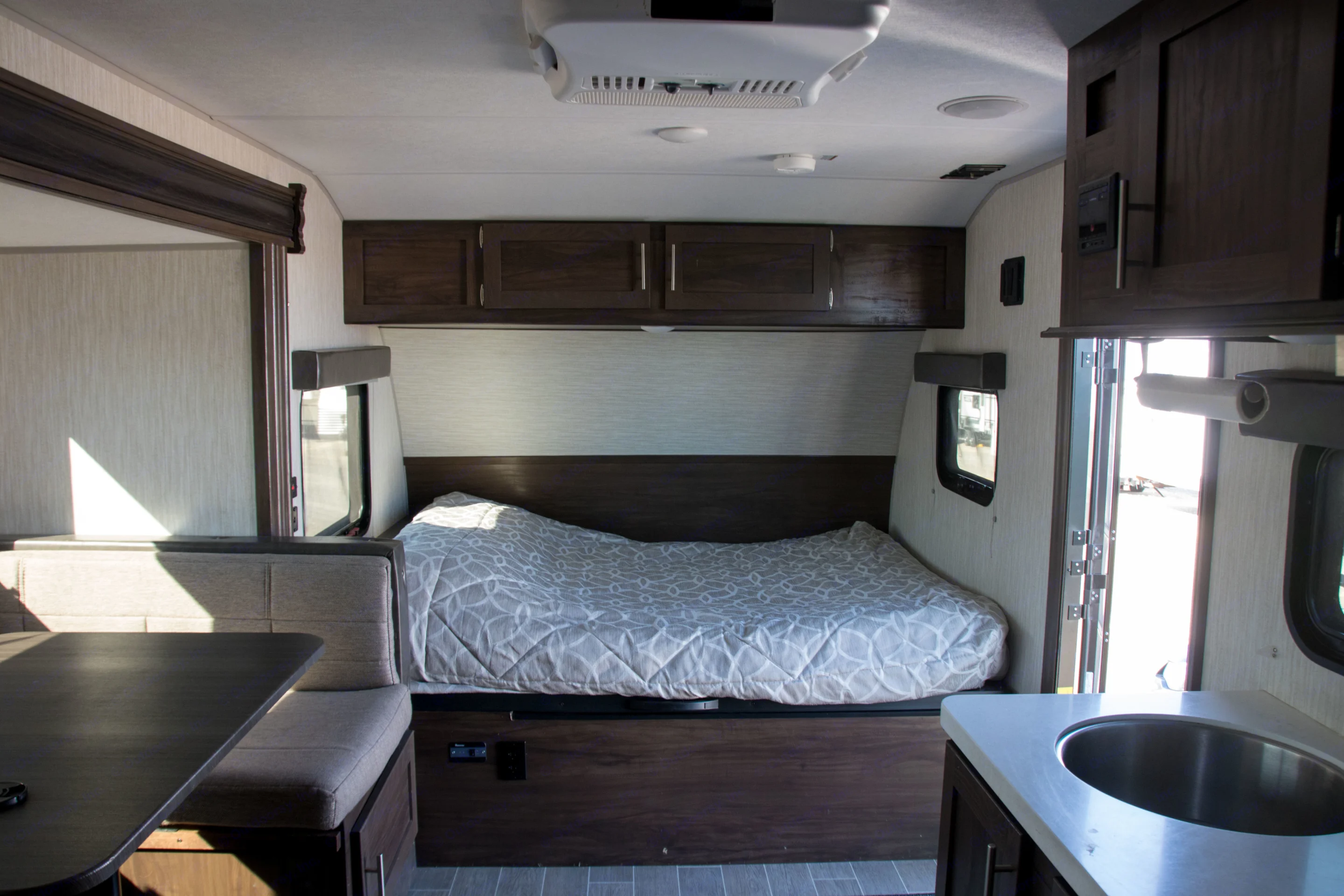 Modern RV rental interior showcasing a bed, din. Forest River Cherokee Wolf Pup Black Label 2020