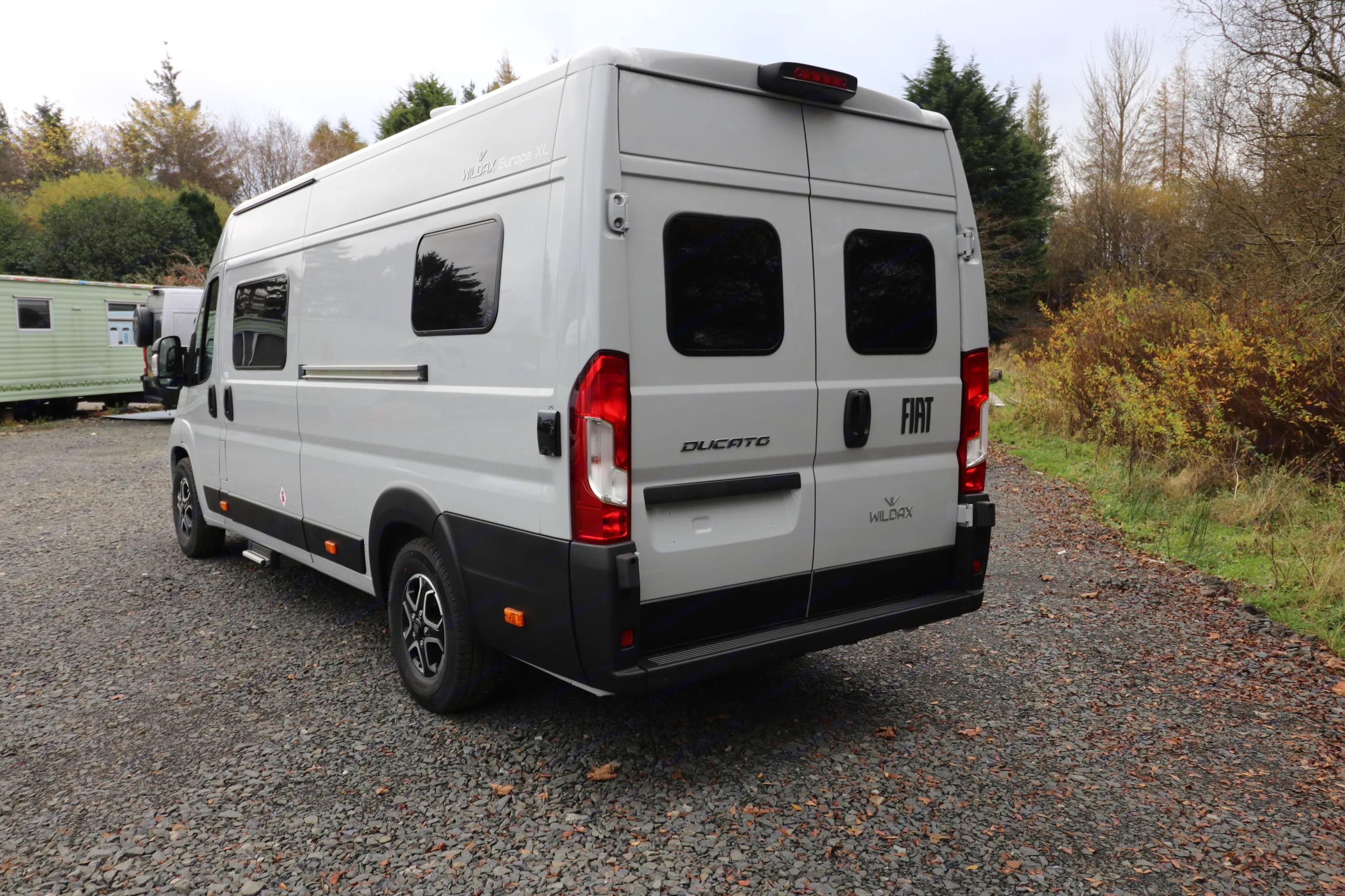 Rear view of a sleek grey Fiat Ducato WildAx camper van on gravel, perfect for. Wildax Europa XL 2025