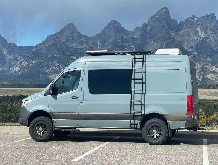 Explore stunning mountains in this light blue Sprinter camper van. An ideal RV rental for off-road adventures and scenic views.. Mercedes 313 CDi 4 X 4 Sprinter 2020
