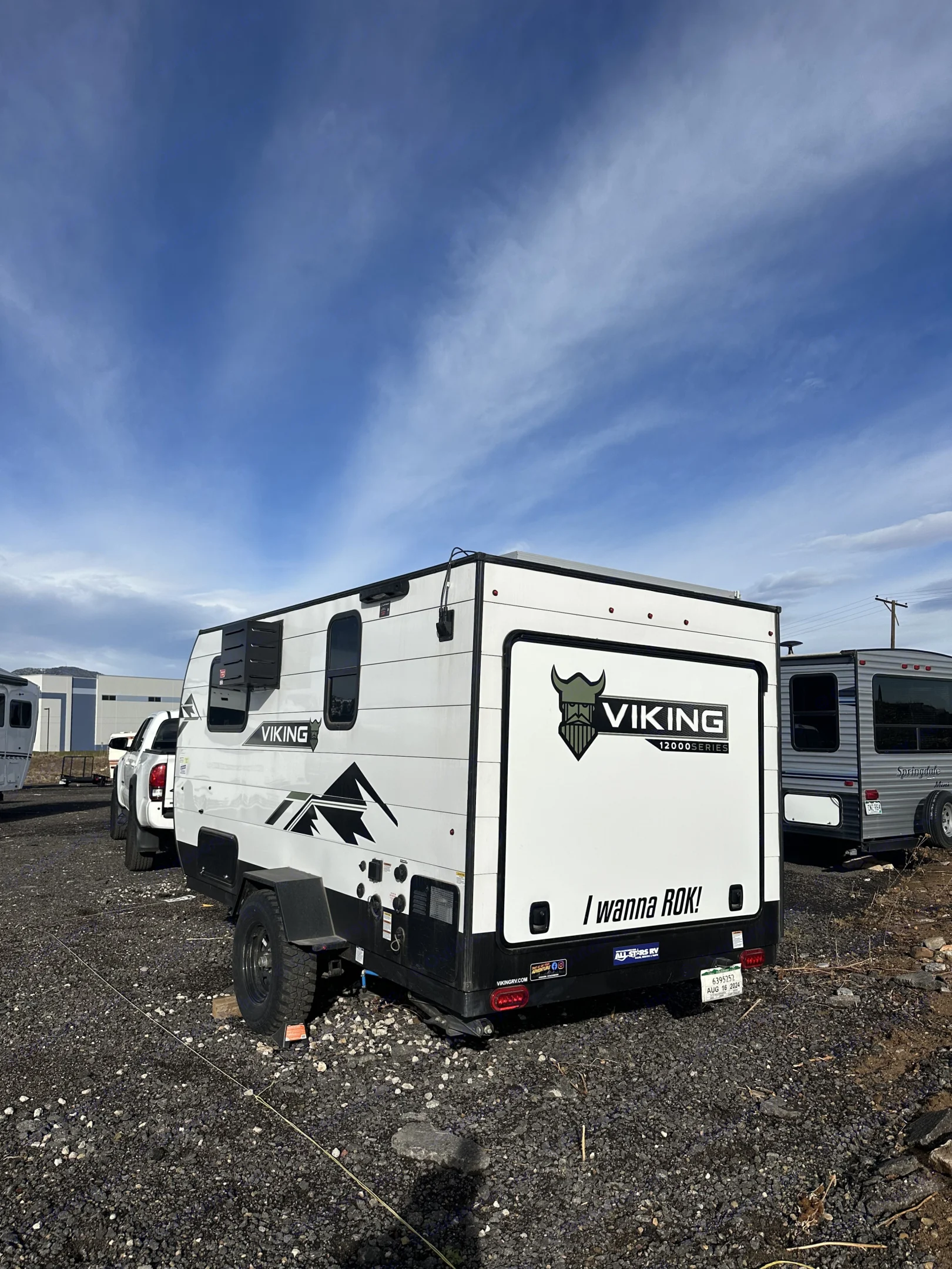 A white Viking travel trailer, likely an RV rental, is parked outside with its "I wanna ROK!" slogan.. Forest River Viking 12000 2024