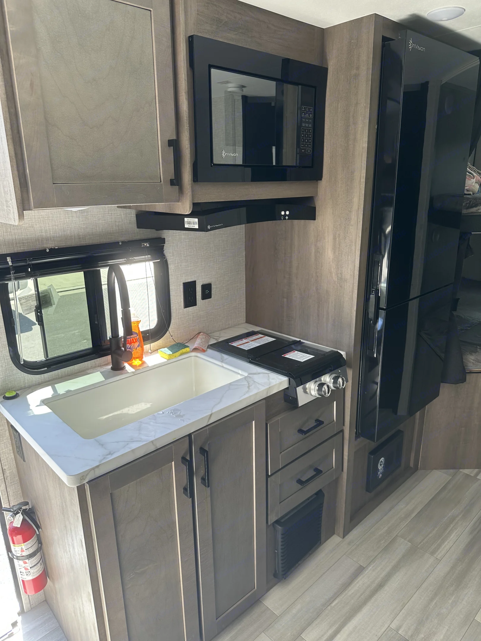 Functional RV rental kitchen: modern sink, microwave, fridge, and stovetop. Well-equipped for travel adventures.. Autumn Ridge 188BHS 2025