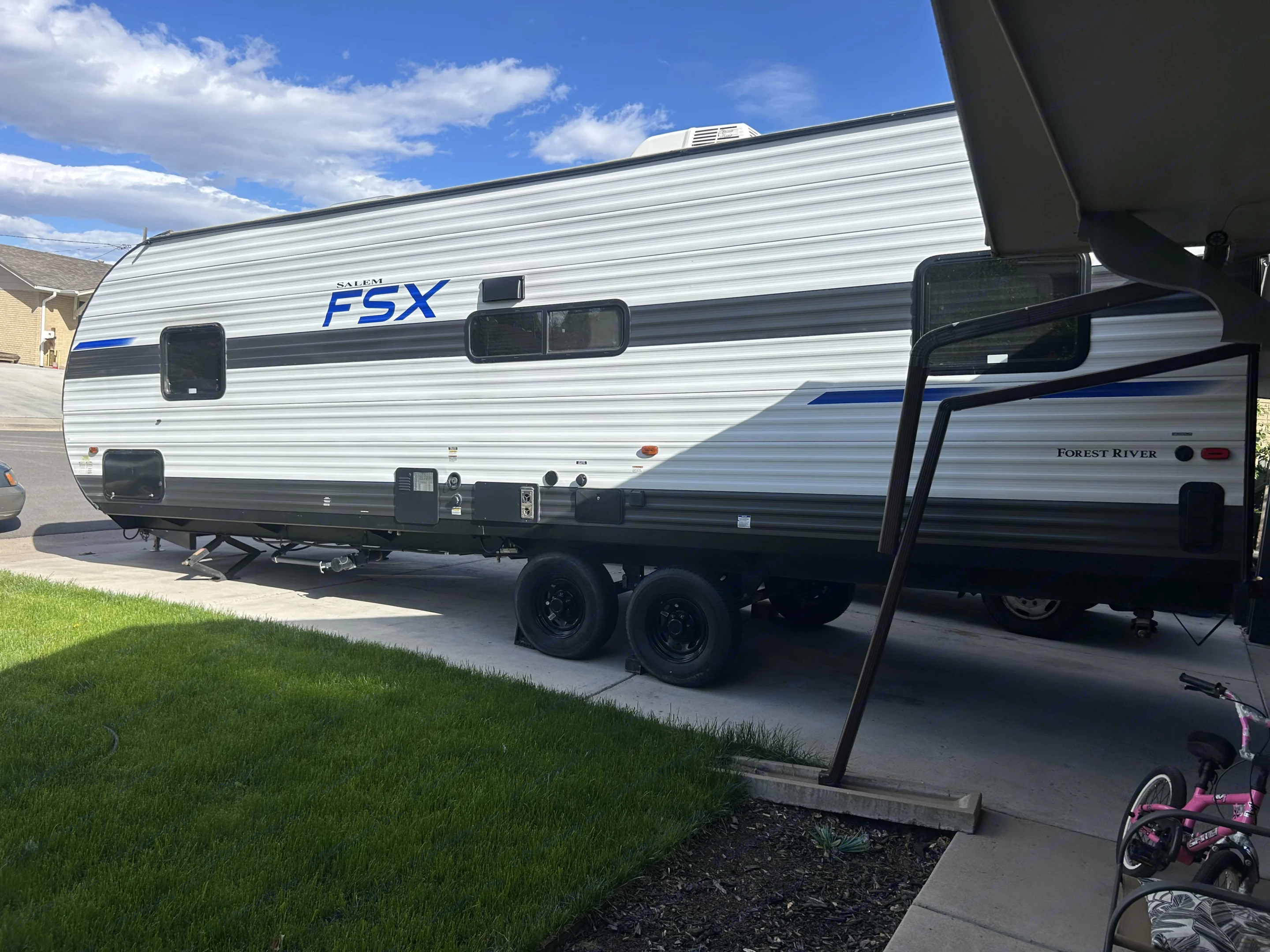 A modern Salem FSX travel trailer (RV) parked in a driveway. Perfect for your next RV rental adventure or outdoor getaway.. Forest River Salem 2021