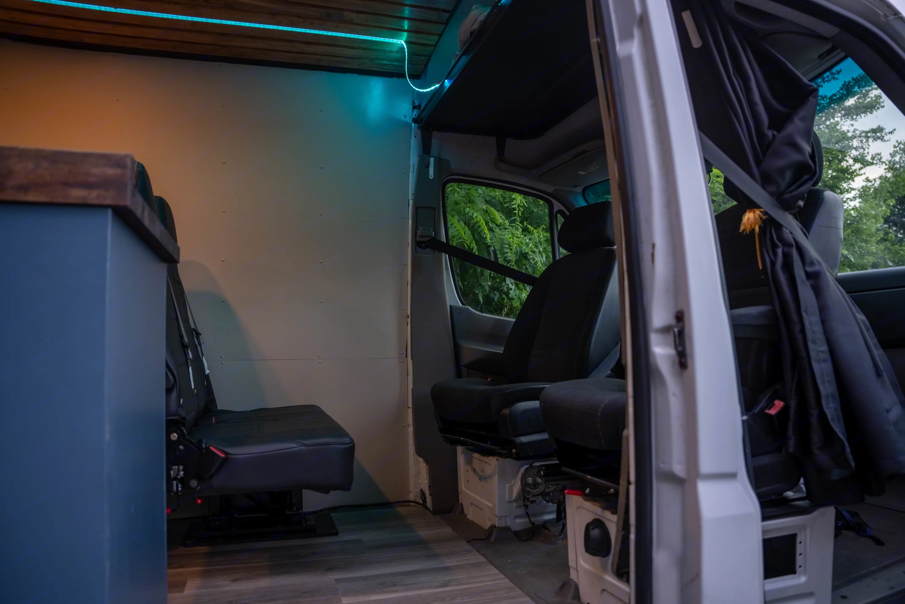 RV rental interior with swiveling passenger seats, blue LED lighting, and a dark wood counter. Ready for adventure.. Mercedes Sprinter 3500 2014