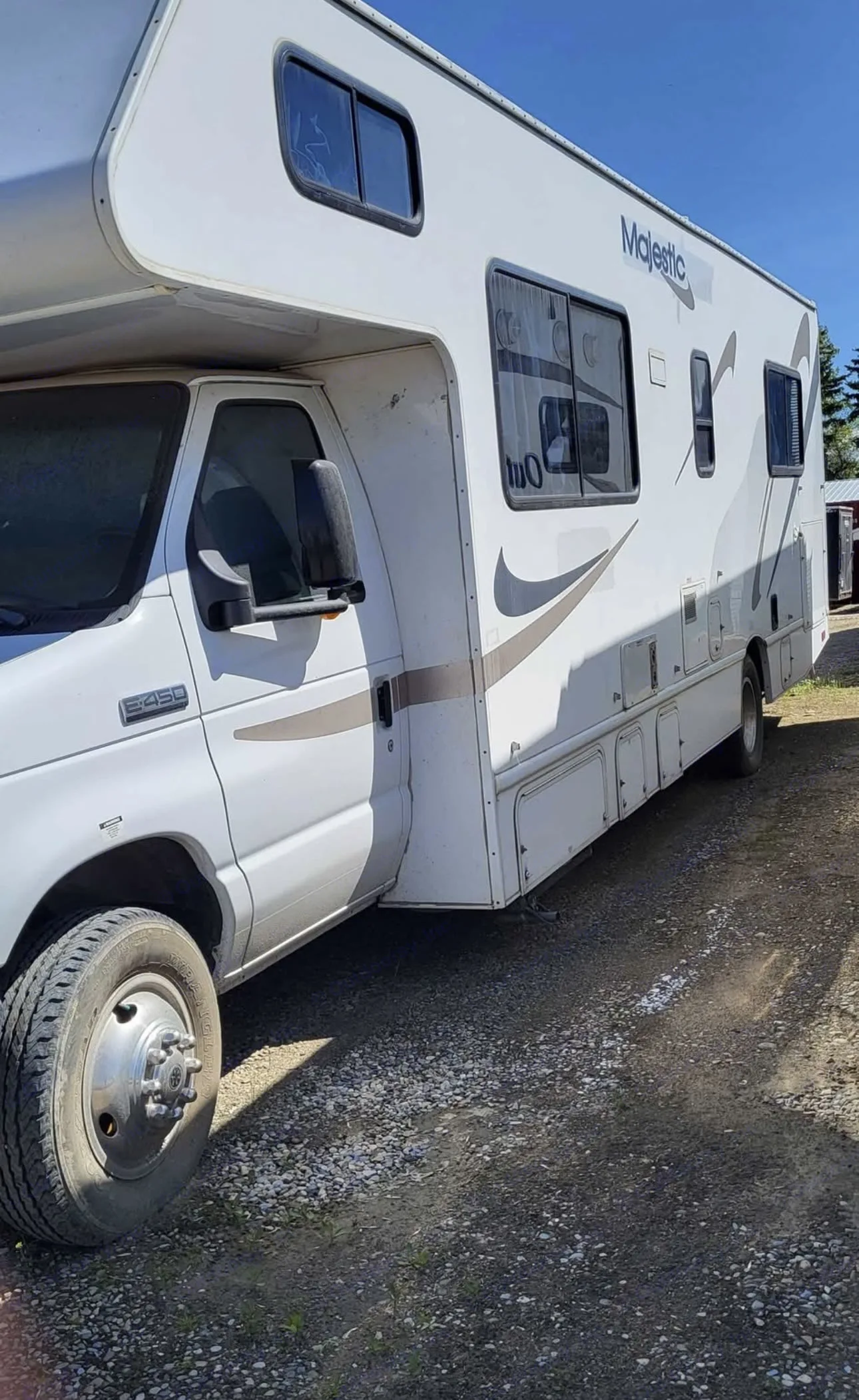 A white Ford E-450 Class C motorhome, a "Majestic" model, parked on gravel. Ready for your next rv rental trip.. Four Winds Majestic 2011
