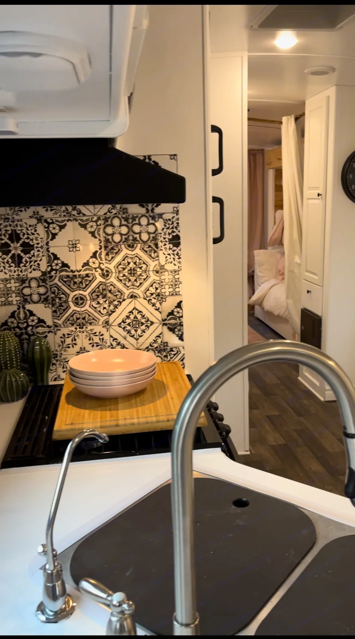 Bright RV rental interior: modern kitchen with black & white tiled backsplash, sink, and a peek into the cozy bedroom.. Jayco Jay Feather Ultra Lite 2019