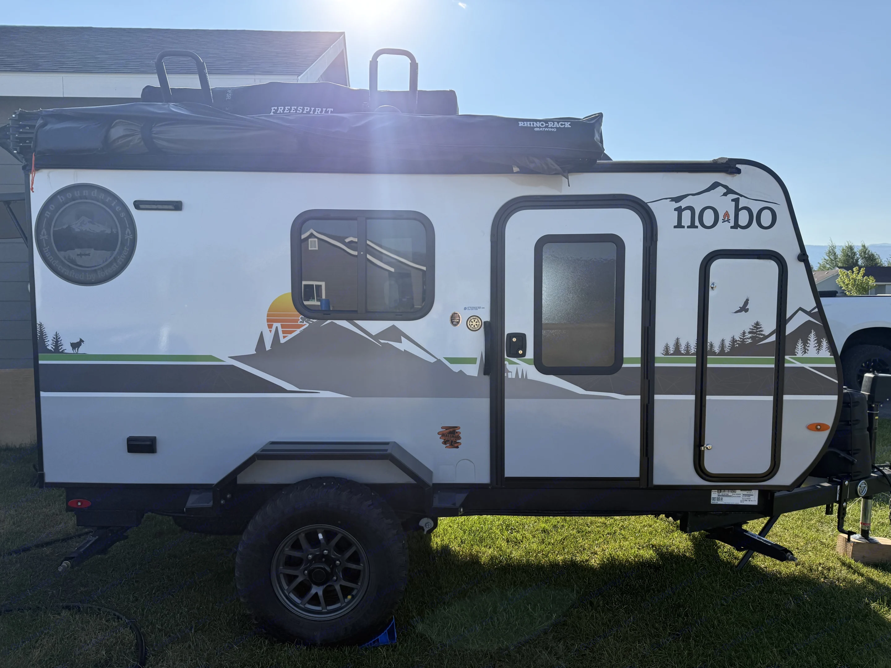 This rugged "No-Bo" travel trailer, equipped with a Freespirit rooftop tent and Rhino-Rack awning, is ideal for an rv rental adventure.. Forest River Nobo 10.7 2024
