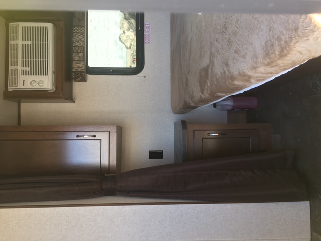 RV rental interior: Cozy bedroom features a bed, AC unit by window, and privacy curtains.. Jayco Jayflight SLX 175XD 2017