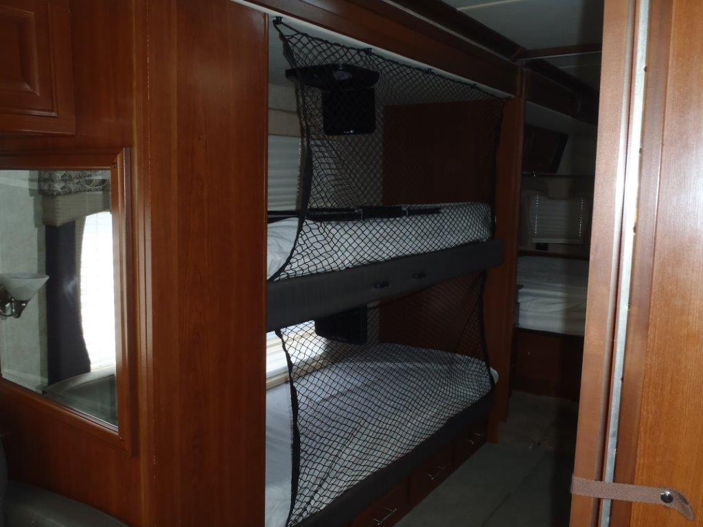 Spacious RV rental interior featuring comfortable bunk beds with safety nets, ideal for family travel.. Fleetwood Discovery