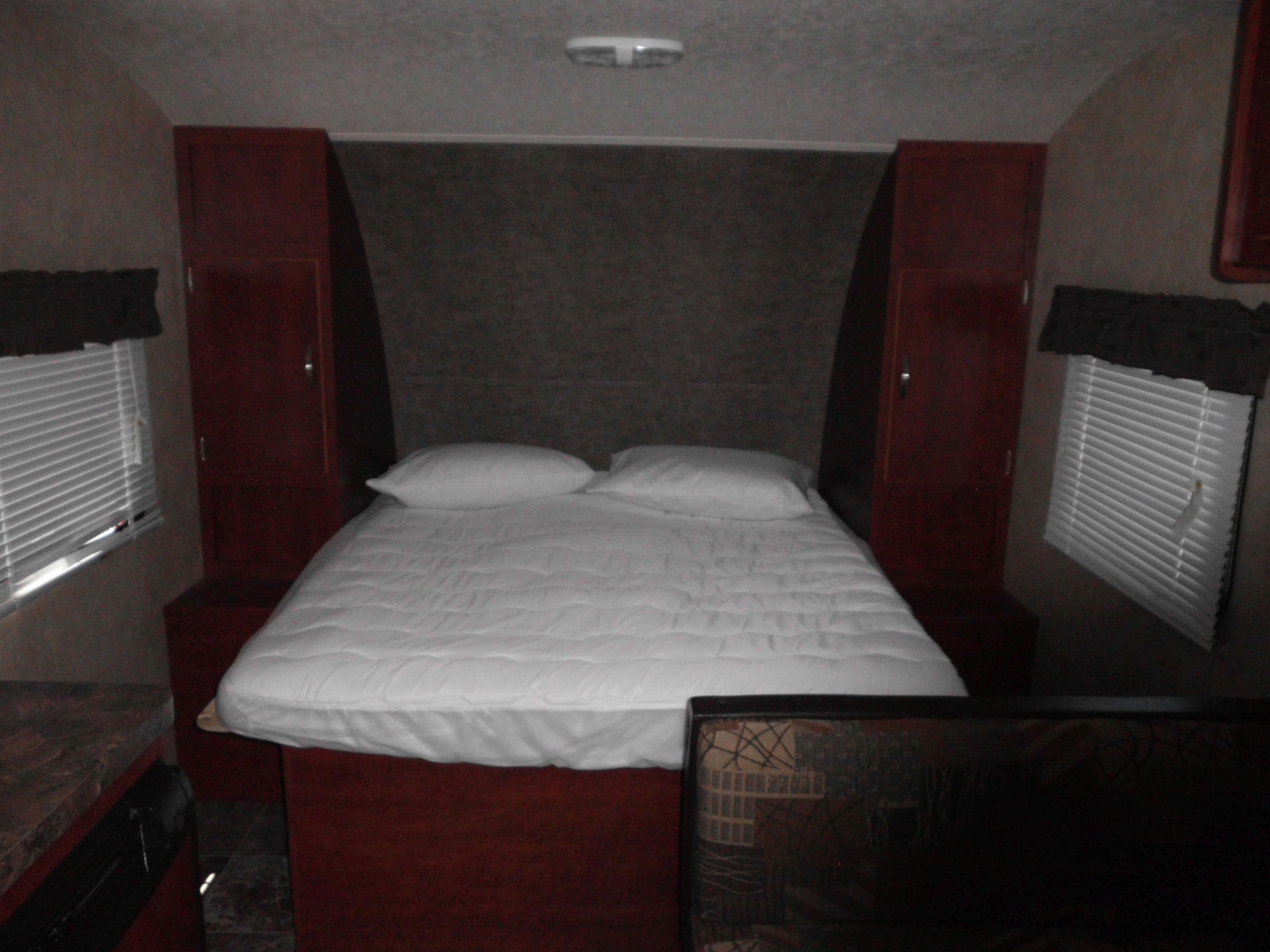 Compact RV rental bedroom featuring a comfy bed, built-in cabinets, and window blinds for privacy.. Salem Cruise Lite 2017