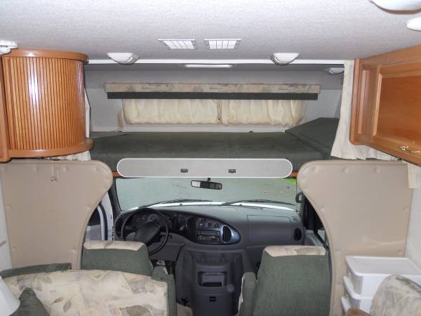 Interior of an RV rental: view shows the cozy overhead bunk, front driver's cabin, and seating in the living area. Perfect for trips!. Fleetwood Tioga 2001