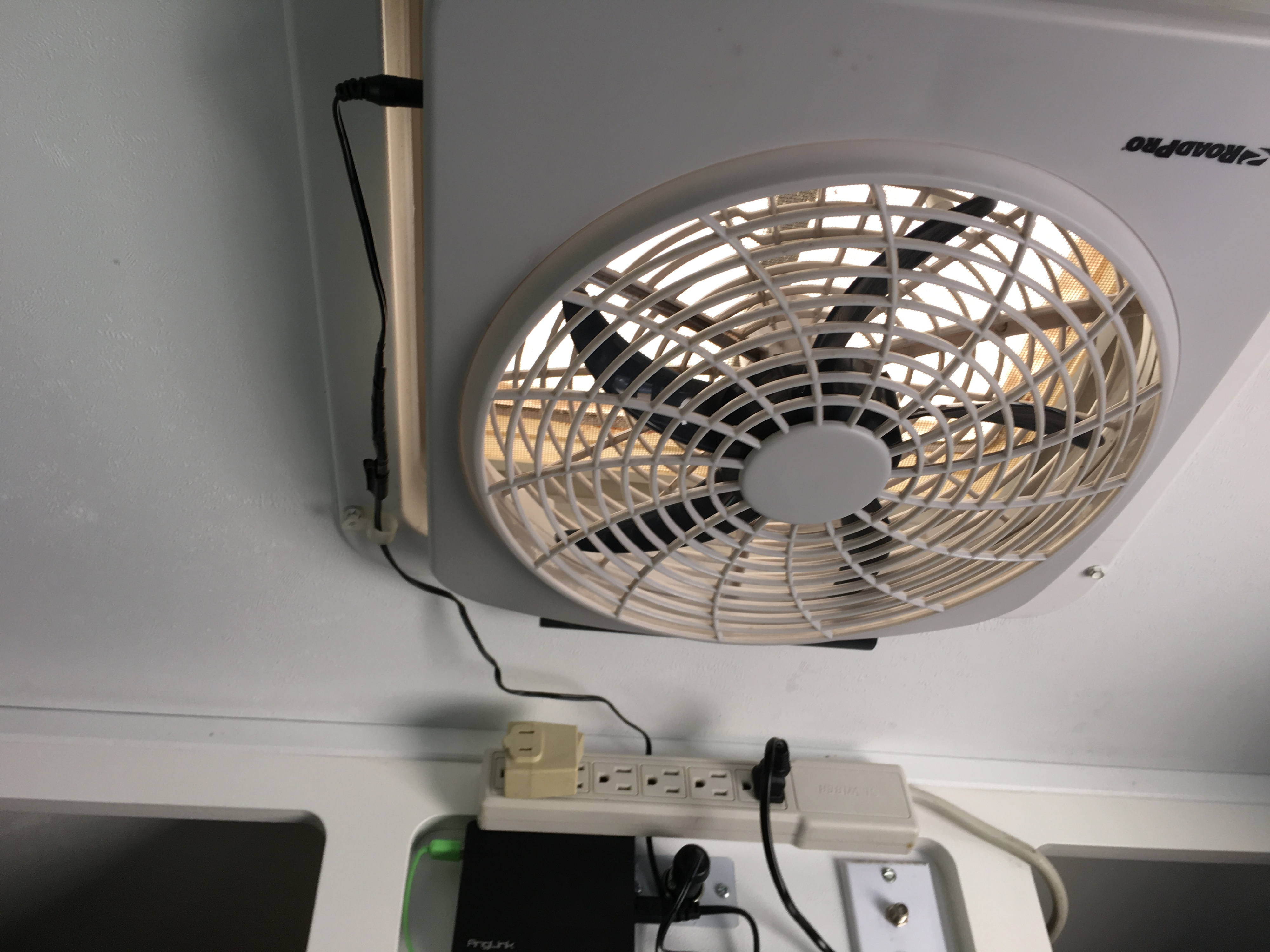 RV rental ceiling fan, power strip, and electronics are seen, providing comfort and connectivity in a compact space.. Little Guy 4 Wide 2008