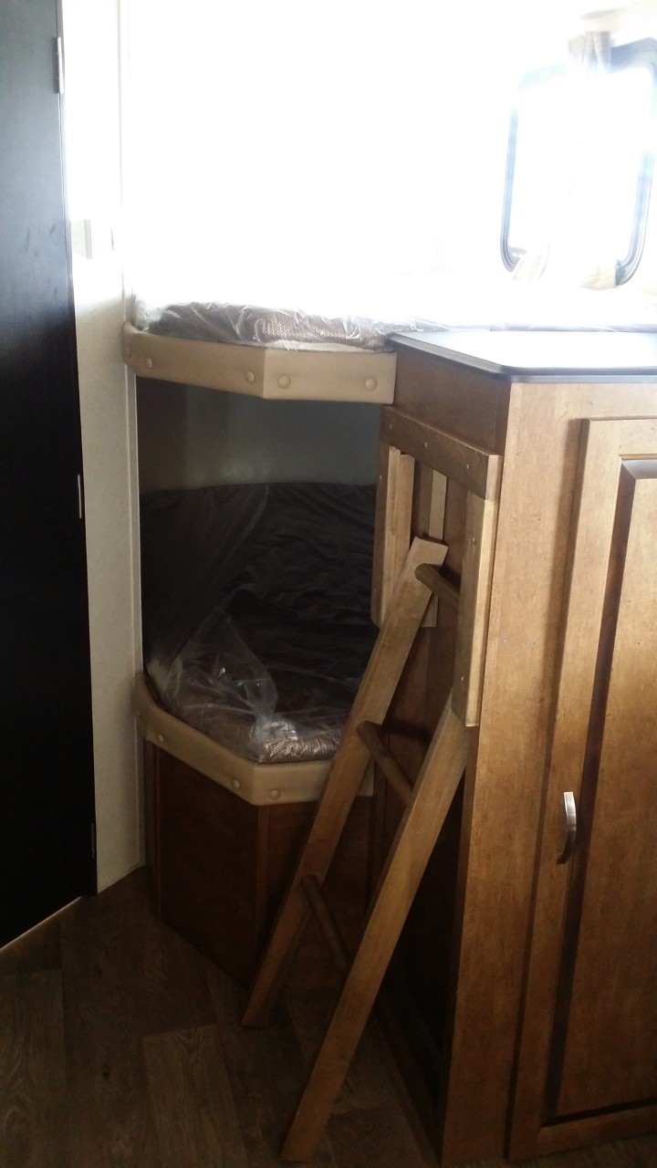 Compact RV rental interior featuring new bunk beds with mattresses, a ladder, and storage cabinets. Ideal sleeping area.. Forest River Salem Cruise Lite 2018