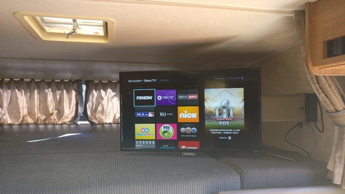 RV rental interior featuring a Sharp Roku TV with streaming apps like Super Bowl LI, providing entertainment in a cozy camper.. Coachmen Freelander 2008