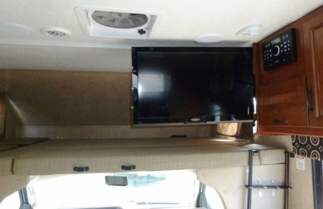RV rental: Cozy cab-over bunk with flat-screen TV and entertainment system, perfect for road trip comfort.. Forest River Sunseeker 2017