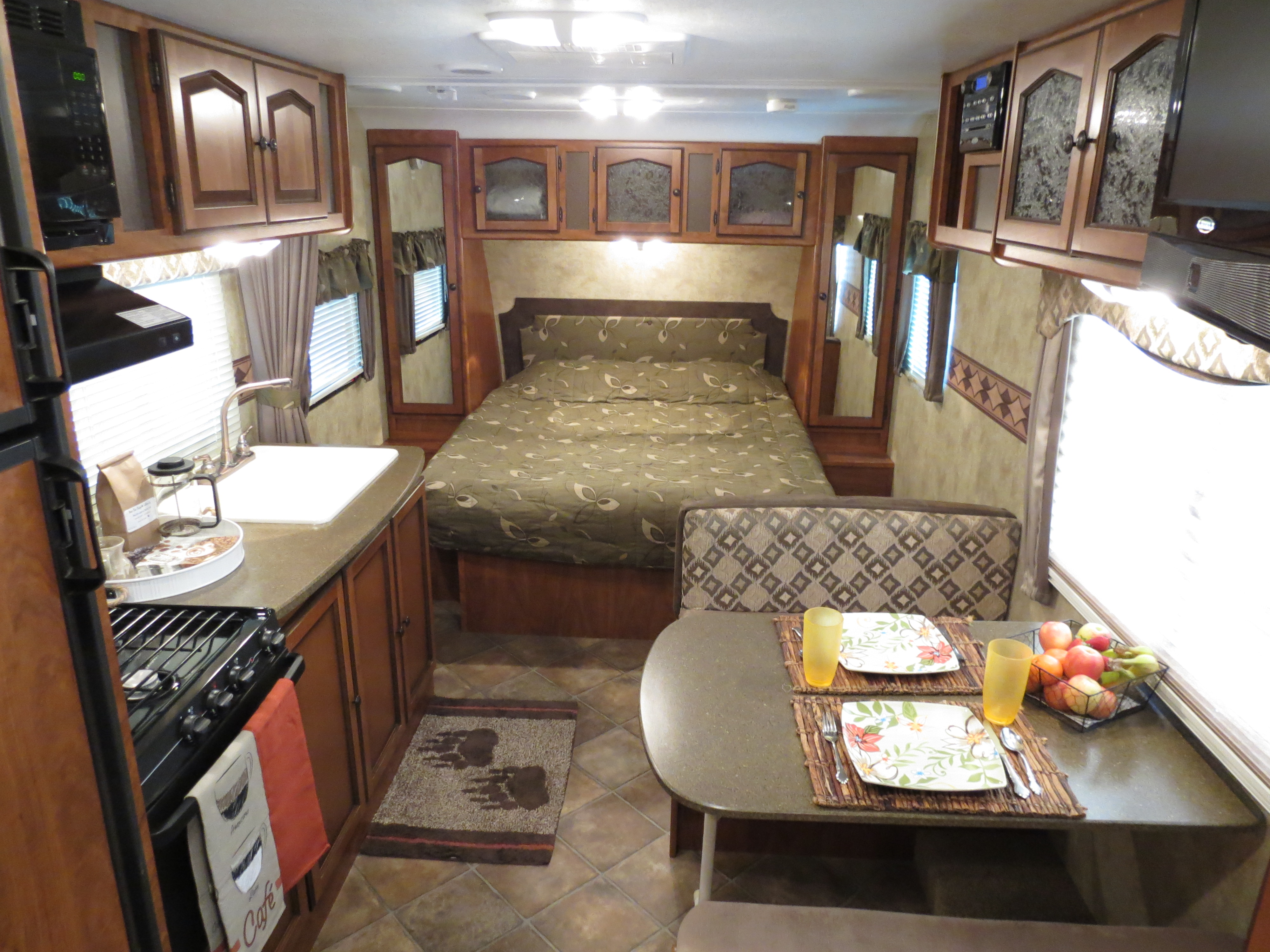 Explore the cozy interior of this RV rental, featuring a full kitchen, comfortable bedroom, and a compact dining area.. Keystone Passport 2011